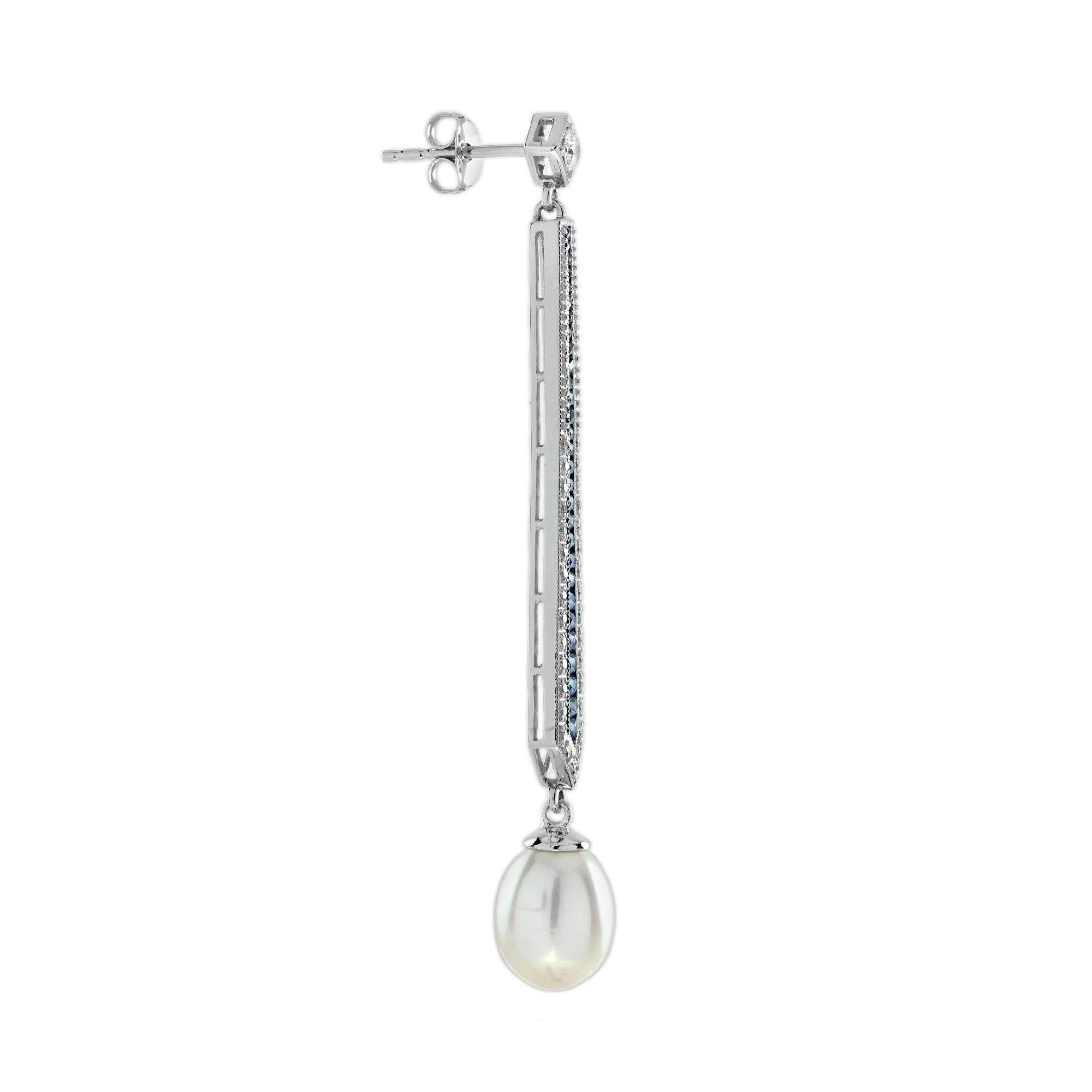Diese exquisiten Ohrringe im Vintage-Stil mit blauem Saphir und Perle vereinen zeitlose Eleganz mit moderner Raffinesse. Die brillanten Diamanten funkeln neben tiefblauen Saphiren und bilden einen atemberaubenden Kontrast. Darunter hängt eine