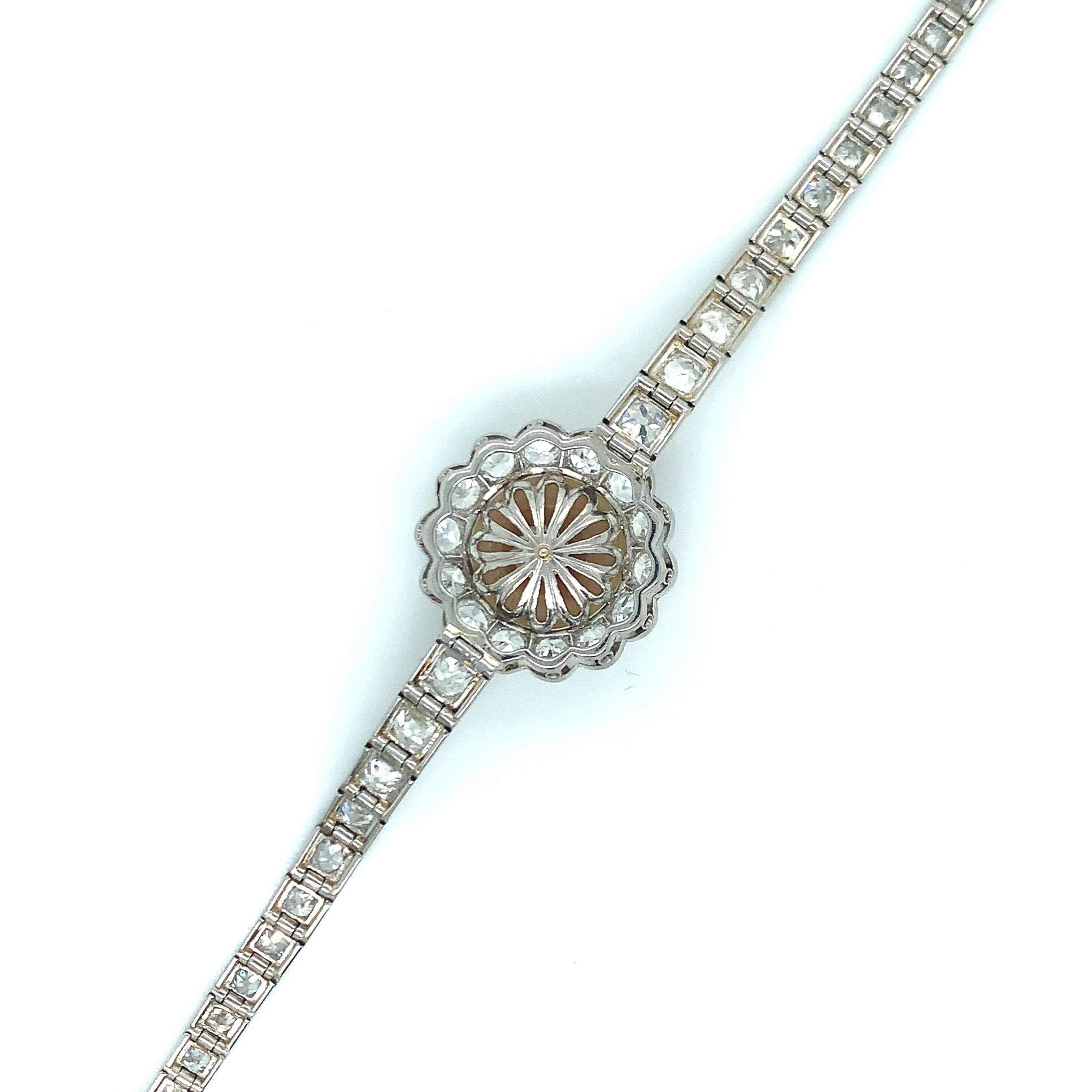 An art deco design, this bracelet has a pearl at its center with diamonds present throughout. Set in platinum, the diamonds weigh approximately 6.5-7 carats. Inner circumference: 7 inches. Total weight: 22.6 grams. 
