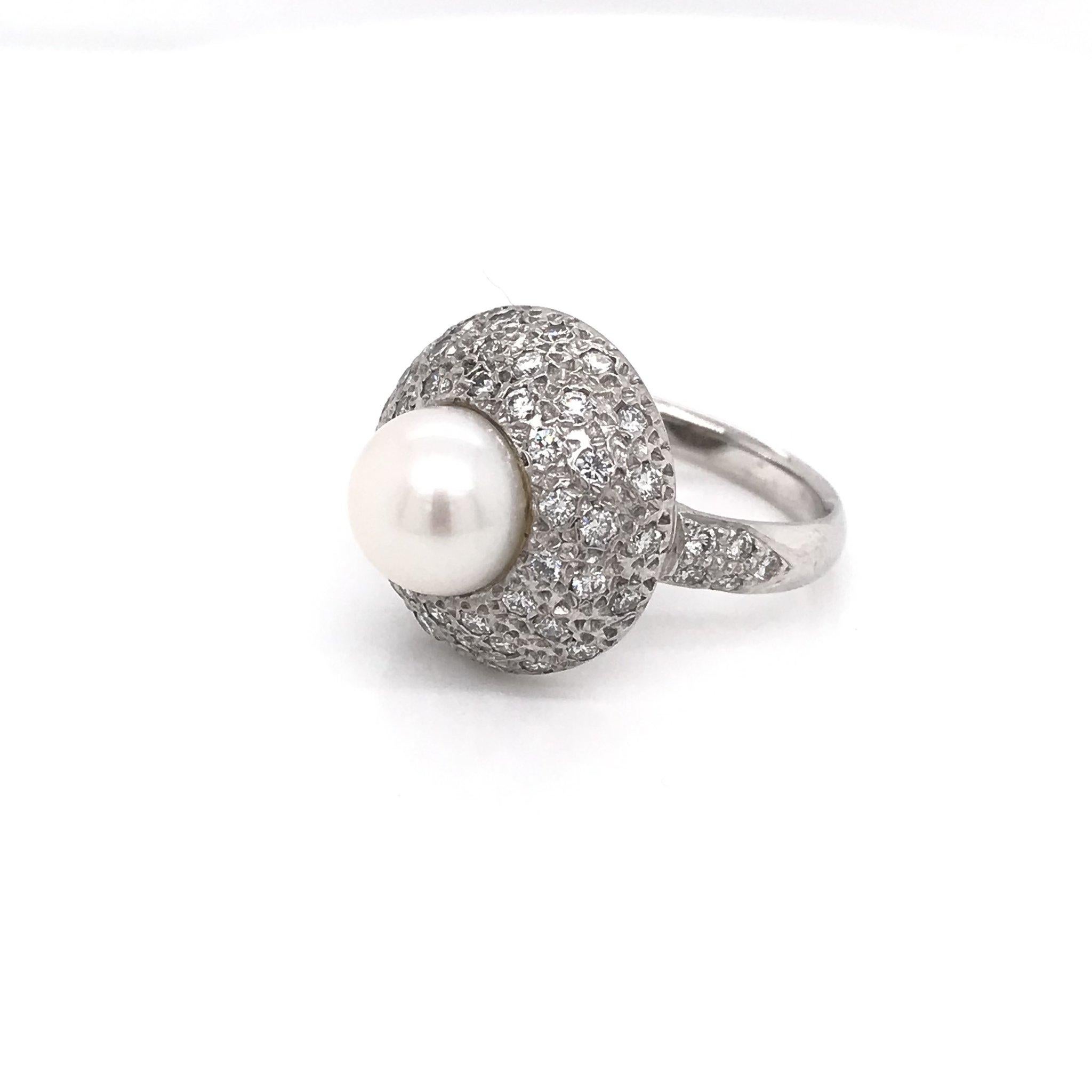 This is an estate piece. This contemporary diamond and pearl ring is 14k white gold and features approximately 1 carat of diamonds combined total weight. The center pearl is saltwater cultured and measures approximately 8.5 mm. The pearl has a good