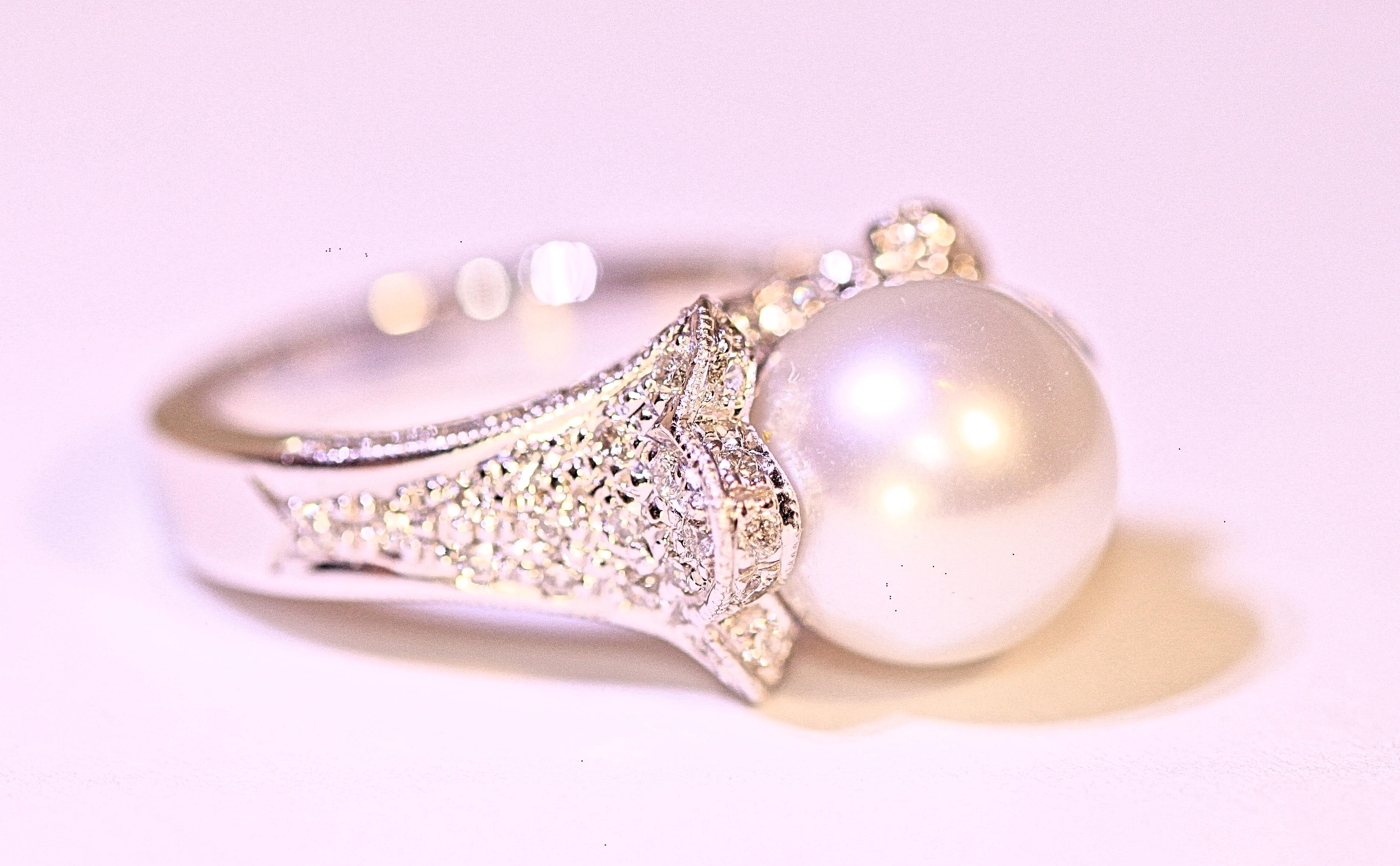 A stunning 14 karat white gold, pearl and diamond ring.  The ring consists of one 10 mm pearl and .98 carat total weight of round brilliant cut diamonds.  The pearl is cream white in color, spherical in shape, very minor blemishes and very good