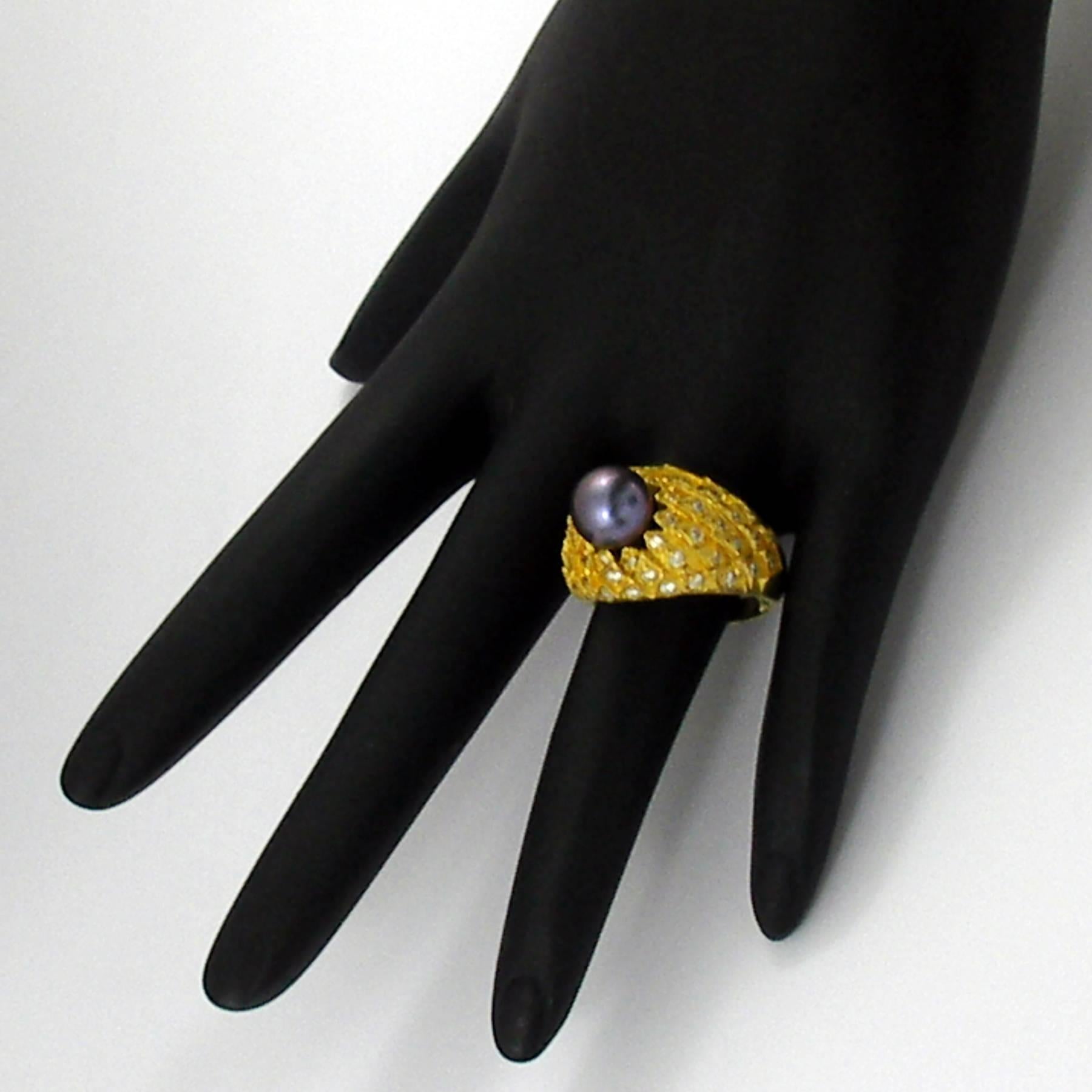 A Peacock designed high karat gold ring centered around one black cultured pearl measuring 9mm, and embellished with assorted round brilliant cut diamonds weighing 0.75ct total approximate weight of overall G color and VS1/VS2 clarity. With a