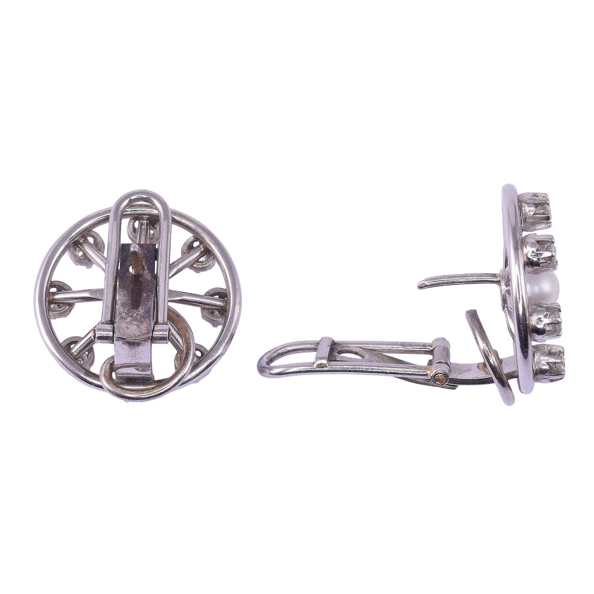 Vintage pearl & diamond spoke design platinum earrings, circa 1950. These round earrings are crafted in platinum with a spoke design featuring a 5.0mm pearl at center and .88 carat total weight of diamonds at the ends of the spokes. The diamonds