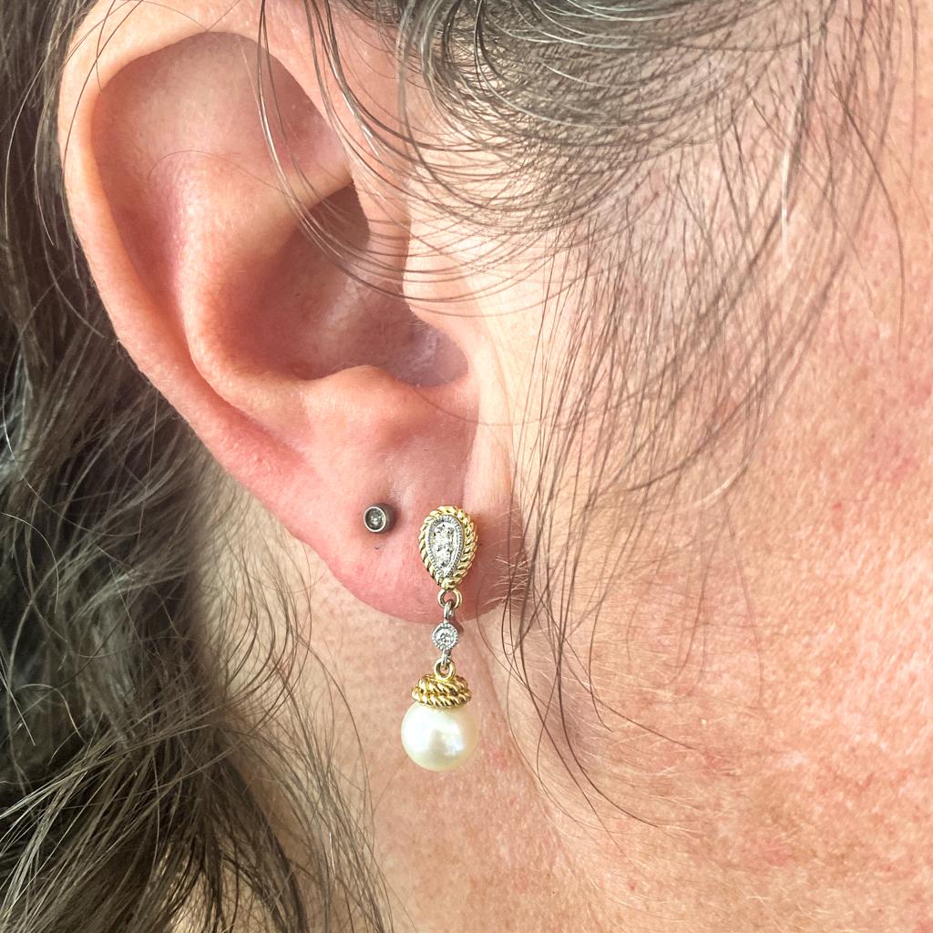 Estos elegantes pendientes de perlas y diamantes de Gabriel & Co. son pura elegancia. Fabricada en una mezcla bicolor de detalles de cuerda de oro amarillo de 14 quilates y engastes de diamantes de oro blanco con bordes detallados milgrain. Son