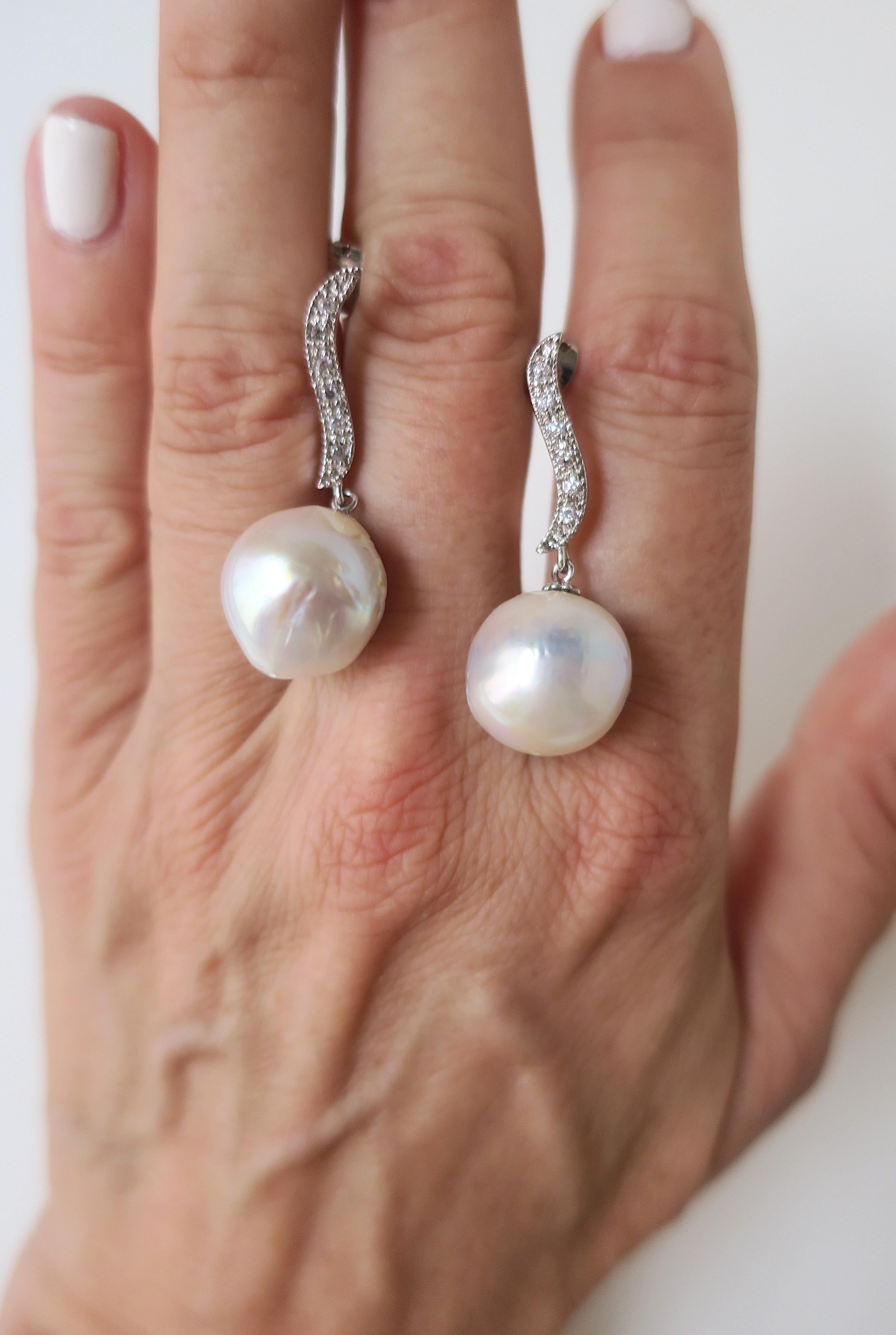 Precioso par de pendientes de gota de perla barroca de agua dulce relativamente grandes y de hermoso brillo. El par es de oro blanco de imitación con diamantes de imitación incrustados y una gota de perla barroca de agua dulce. La perla tiene un