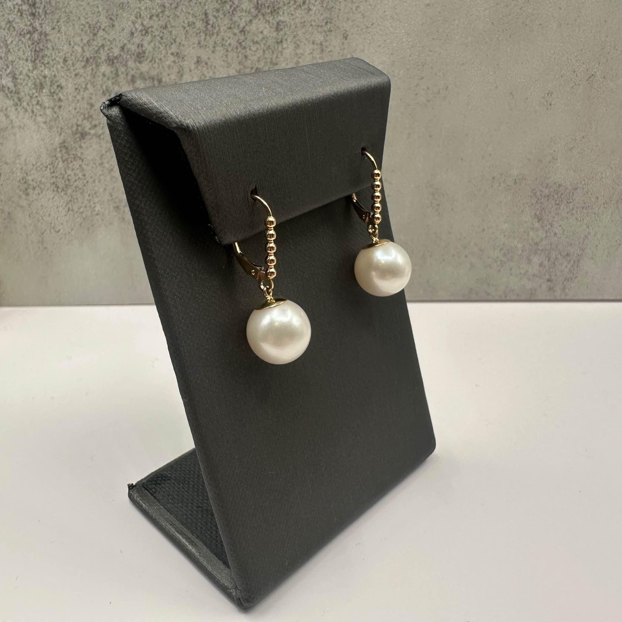 These elegant Pearl Drop Earrings in 14kt yellow gold feature 12mm freshwater pearls, offering a classic and sophisticated look. Weighing 4.9 grams, these earrings provide a substantial feel without being too heavy, making them perfect for both