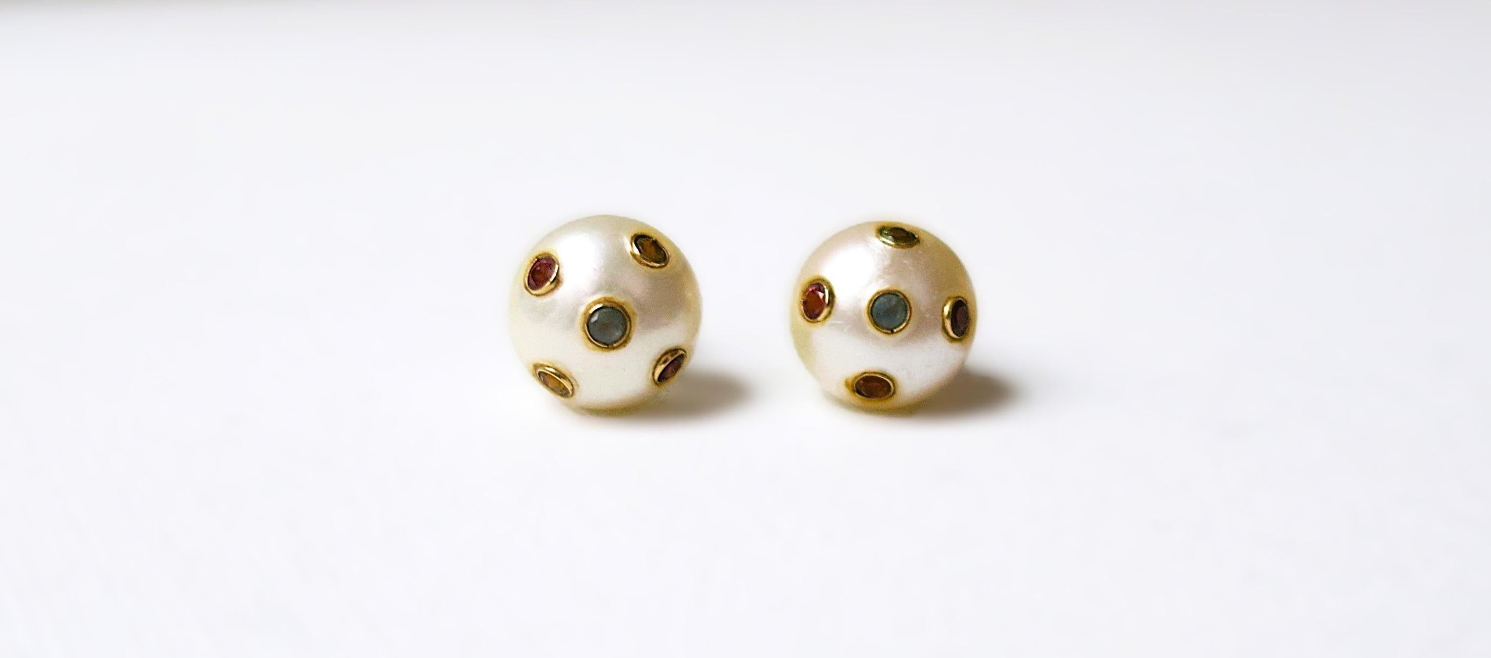A pair of white freshwater pearl 11mm stud earrings with round brilliant-cut gemstones inset into 14k yellow gold setting and posts. Backs are 18k white gold, marked '750'. 