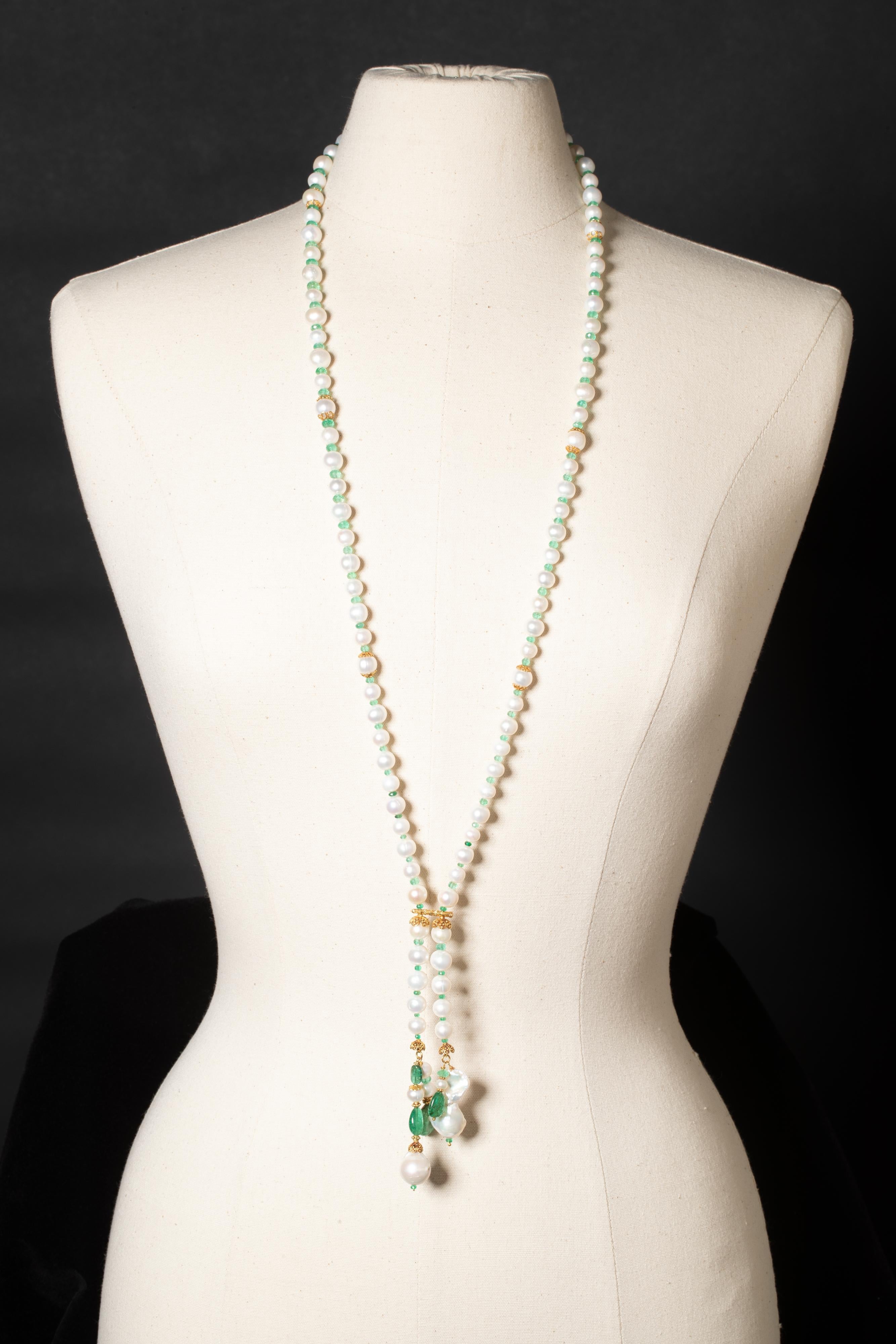 A fresh water pearl lariat necklace with faceted Colombian emeralds and 22K gold.  It also features baroque pearls at the bottom, gold beads and end caps, and tumbled emeralds.  This can be work long or short which makes it quite versatile.  The
