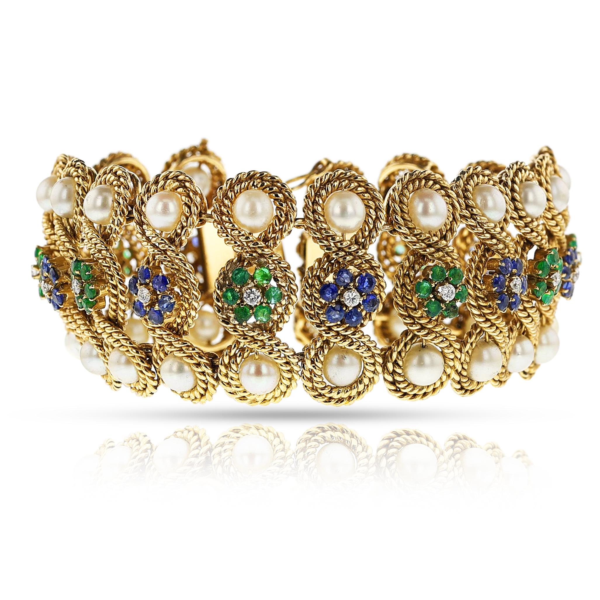 Bracelet de perles, d'émeraudes, de diamants et de saphirs en métal 18 carats à motifs entrelacés. Le bracelet est orné de perles de culture et de fleurs avec émeraude, saphir et diamants. La longueur est d'environ 7,20 pouces. Le poids total du