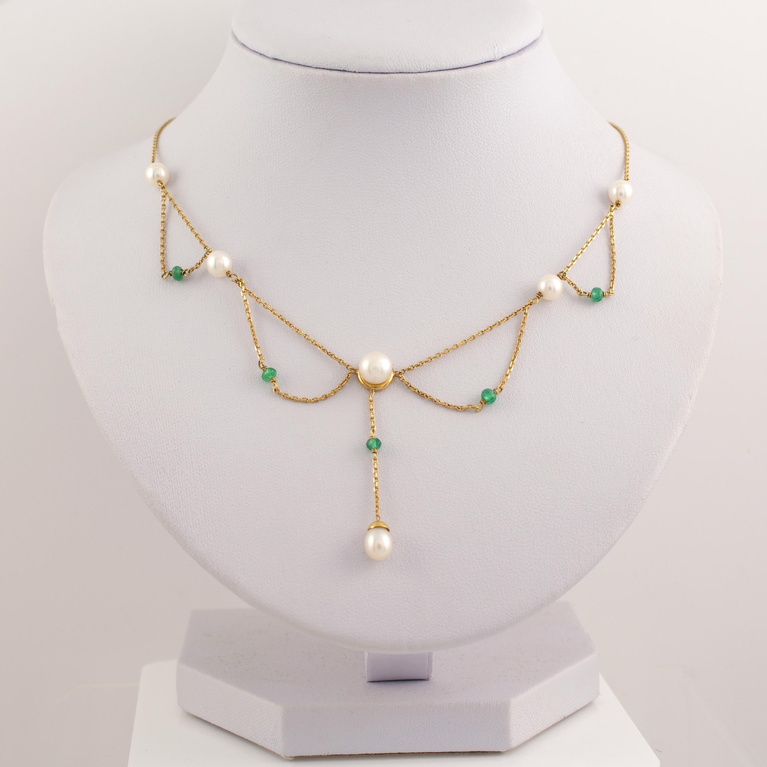 This delicate Y necklace displays cultured pearls festooned with separate small gold links set with small emerald beads. The necklace is light in weight, hangs gracefully and looks beautiful.

•  Dimensions: 15 inches in length (not including the