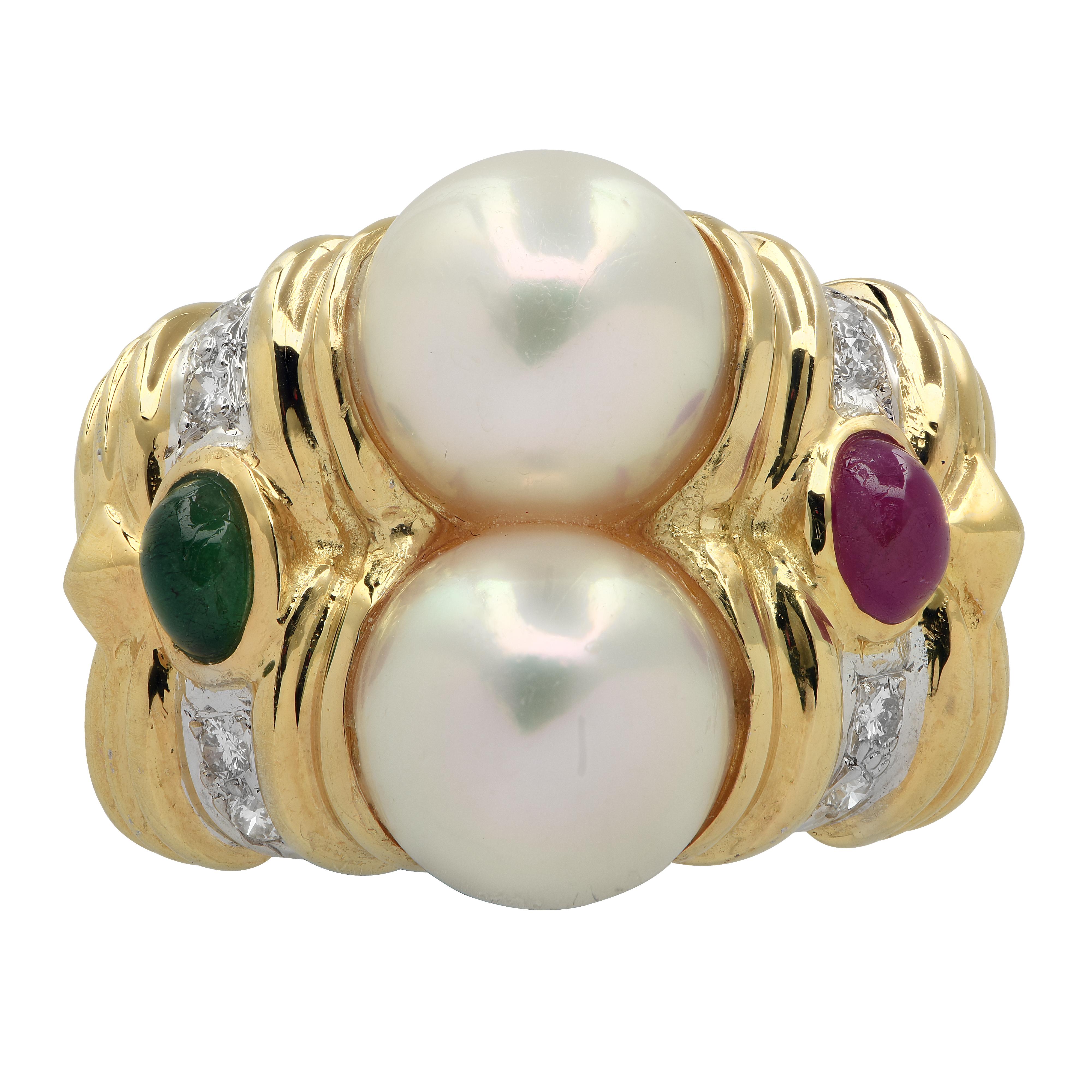 Gorgeous ring crafted in 18 karat yellow gold showcasing 2 freshwater pearls measuring 8mm in diameter, an emerald and a ruby cabochon weighing approximately .20 carats total, and 8 round brilliant cut diamonds weighing approximately .08 carats, G