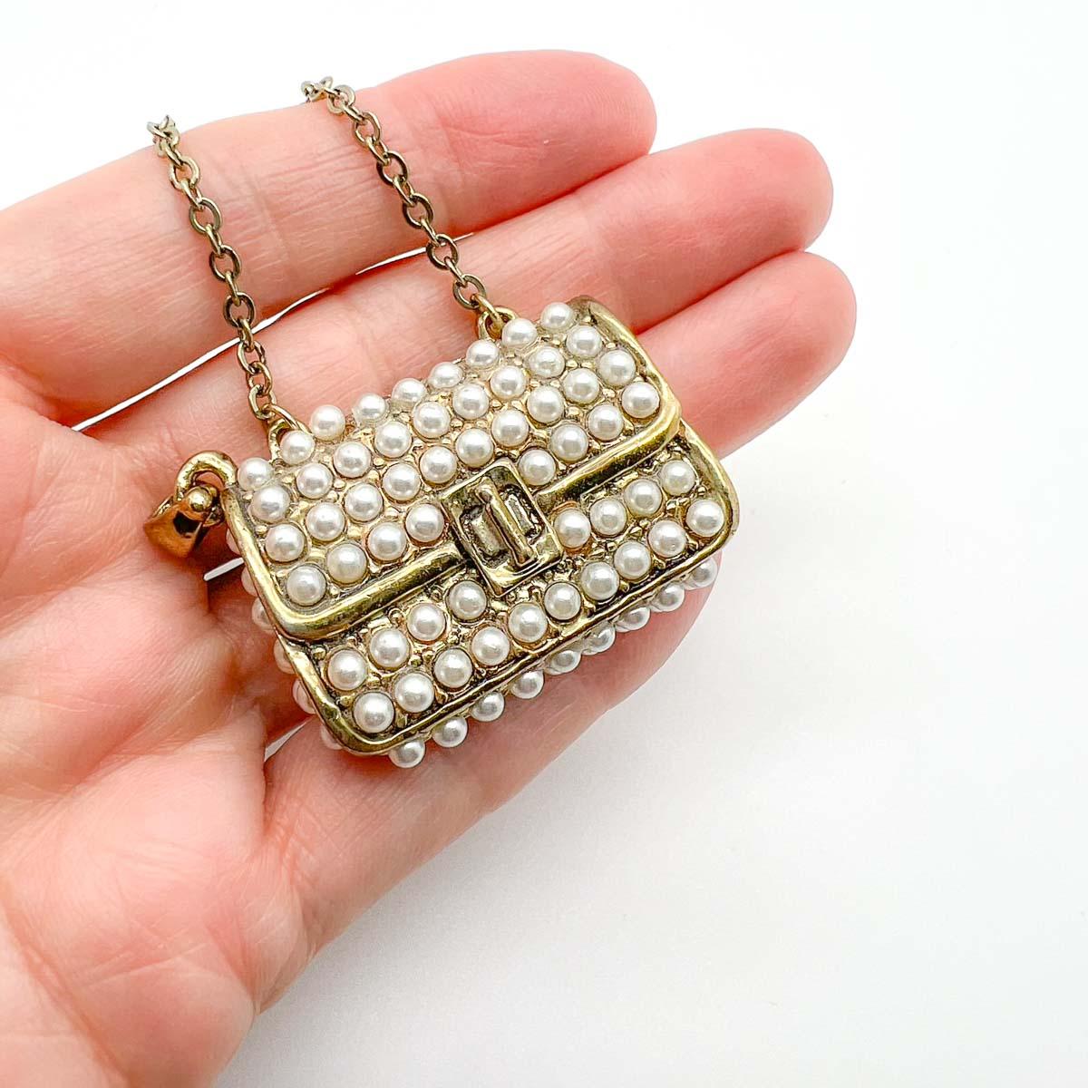 An adorable pearl encrusted handbag pendant to add to your favourite chains for a touch of style. Lustrous faux half pearls adorn the bag front and sides. A wonderfully chic charm.

Vintage Condition: Very good without damage or noteworthy