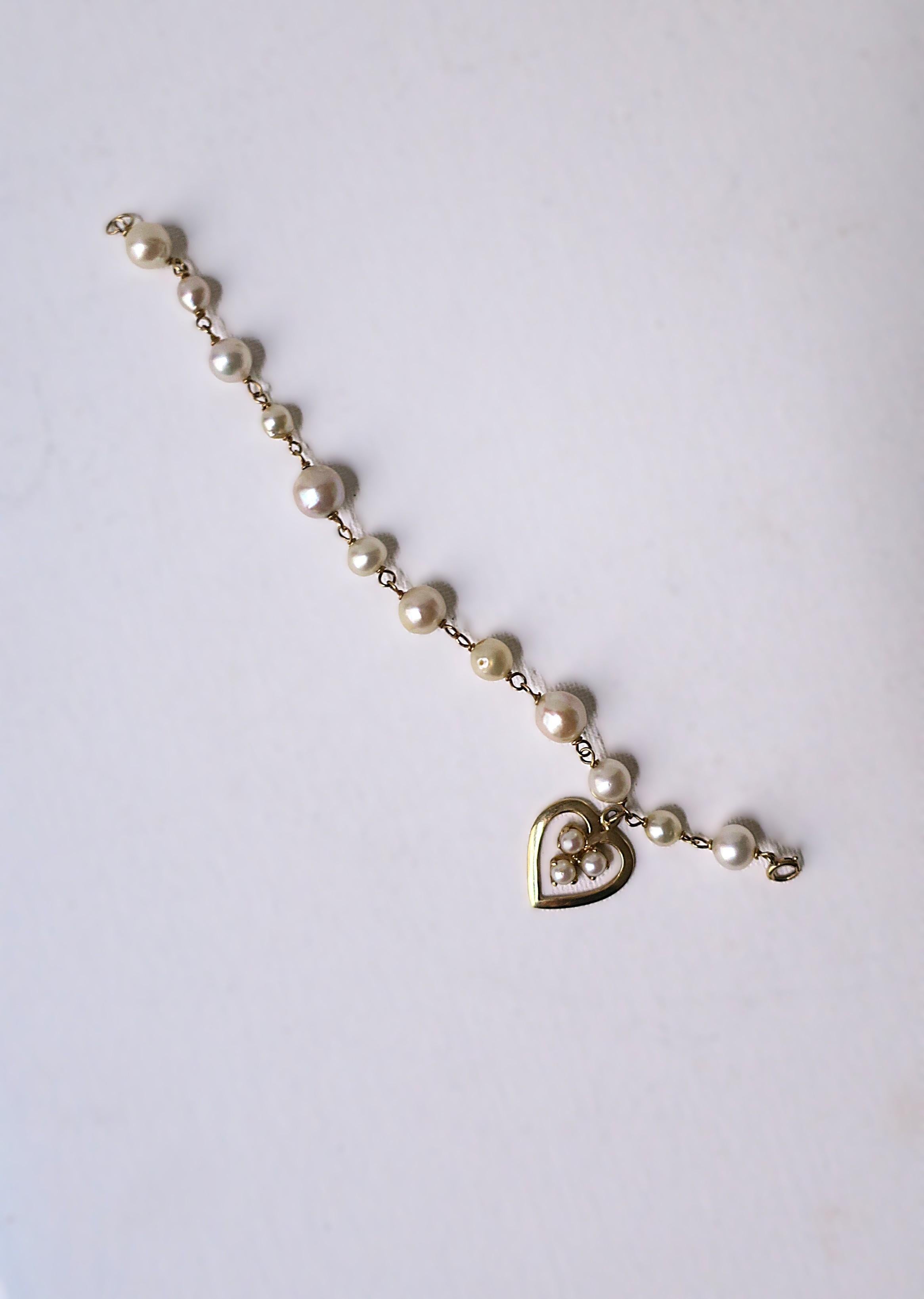 Bellissimo bracciale con charm a forma di cuore in perle coltivate e oro giallo 14kt, circa metà del XX secolo. Le perle sono coltivate, di varie dimensioni/forma, con una bellissima lucentezza. Queste perle, dodici (12), più tre (3) a cuore, hanno