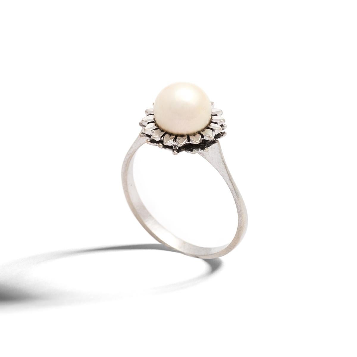 Pearl white gold Ring representing a stylized flower.
Pearl diameter: 7.50 millimeters.
Ring size: 6 1/2.
Gross weight: 3.07 grams.
