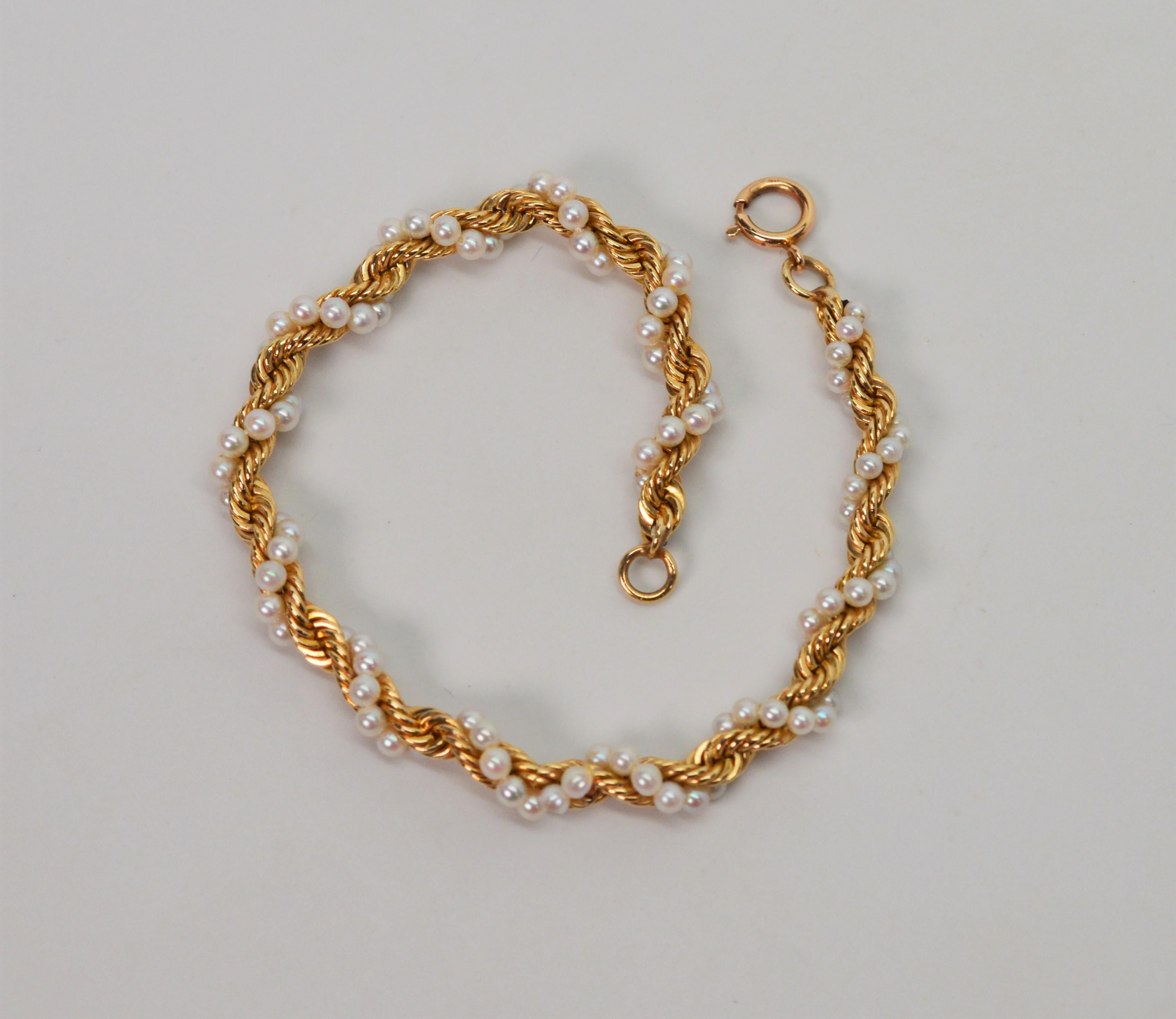 Simple and elegant. Ten carat braided yellow gold rope chain wrapped with a creamy white strand of natural 2-1/2 mm Akoya pearls.
Measures seven inches and is finished with a spring ring closure. In gift box. 