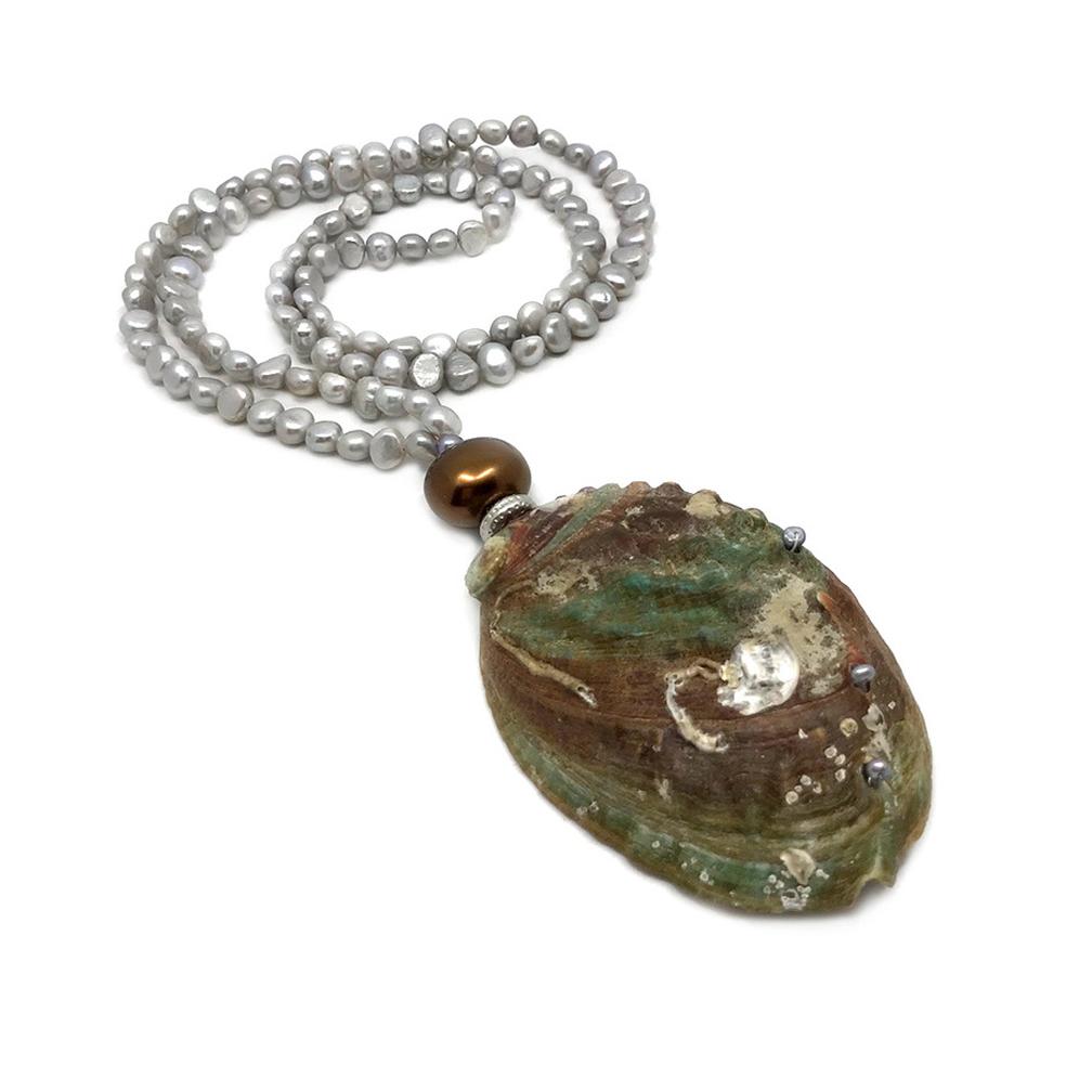 Nouveau Boutique created this pearl in oyster shell necklace combining freshwater pearls and shell beads. Three rows ofpearls are hand-wired into a beautiful natural lustrous oyster shell as the pendant and connected to a long strand of small potato