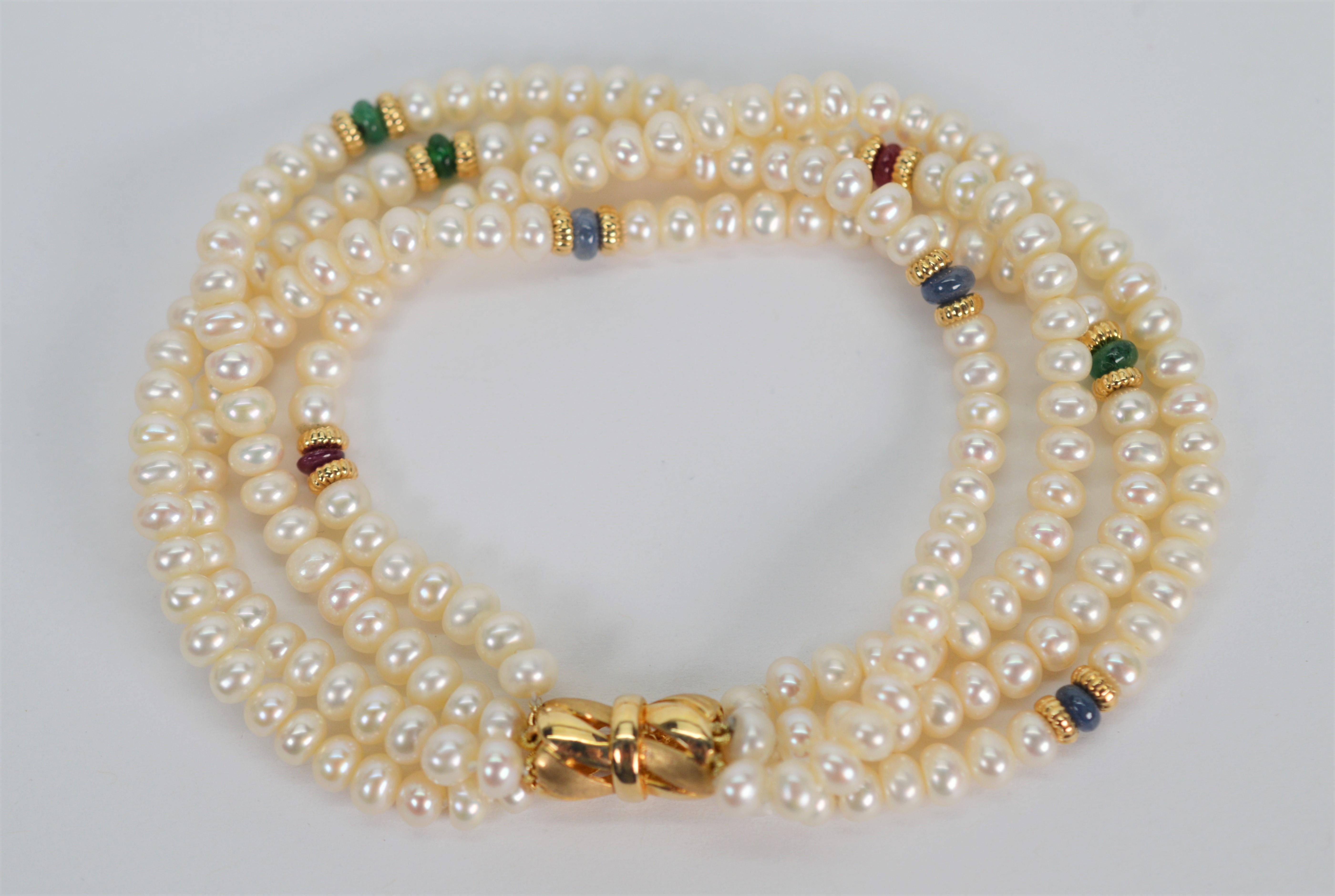 Fours strands of silky button pearls accented with colorful green jade  blue lapis and pink ruby gemstone beads create this versatile eight inch bracelet. Featured is an attractive 15.5mm decorative clasp of fourteen karat yellow gold with an