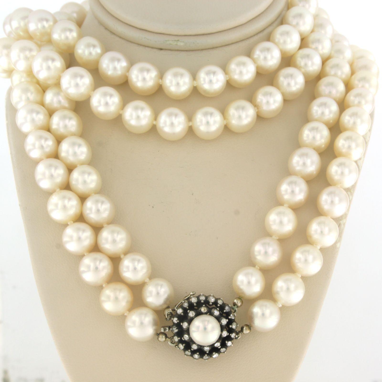 14k gold with silver clasp set with a central pearl and an entourage of rose diamonds. 0.40ct on a double row pearl necklace

Detailed description

the pearl necklace is approximately 60 cm long and 1.6 cm wide

The size of the lock is 1.6 cm high