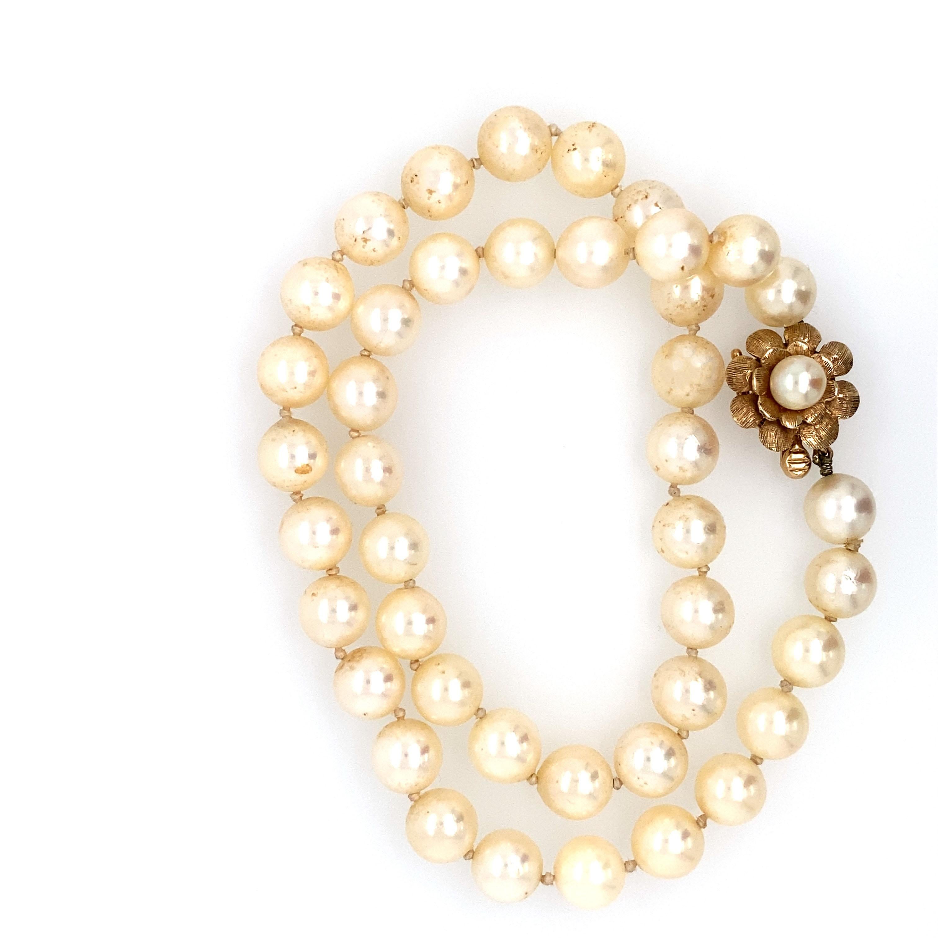 Circa: 1980
Metal Type: 14 karat yellow gold 
Length: 15 inches

Each pearl is 8 millimeter 
One pearl strand makes up the necklace 
The clasp is floral shaped with high contrast textured gold. 