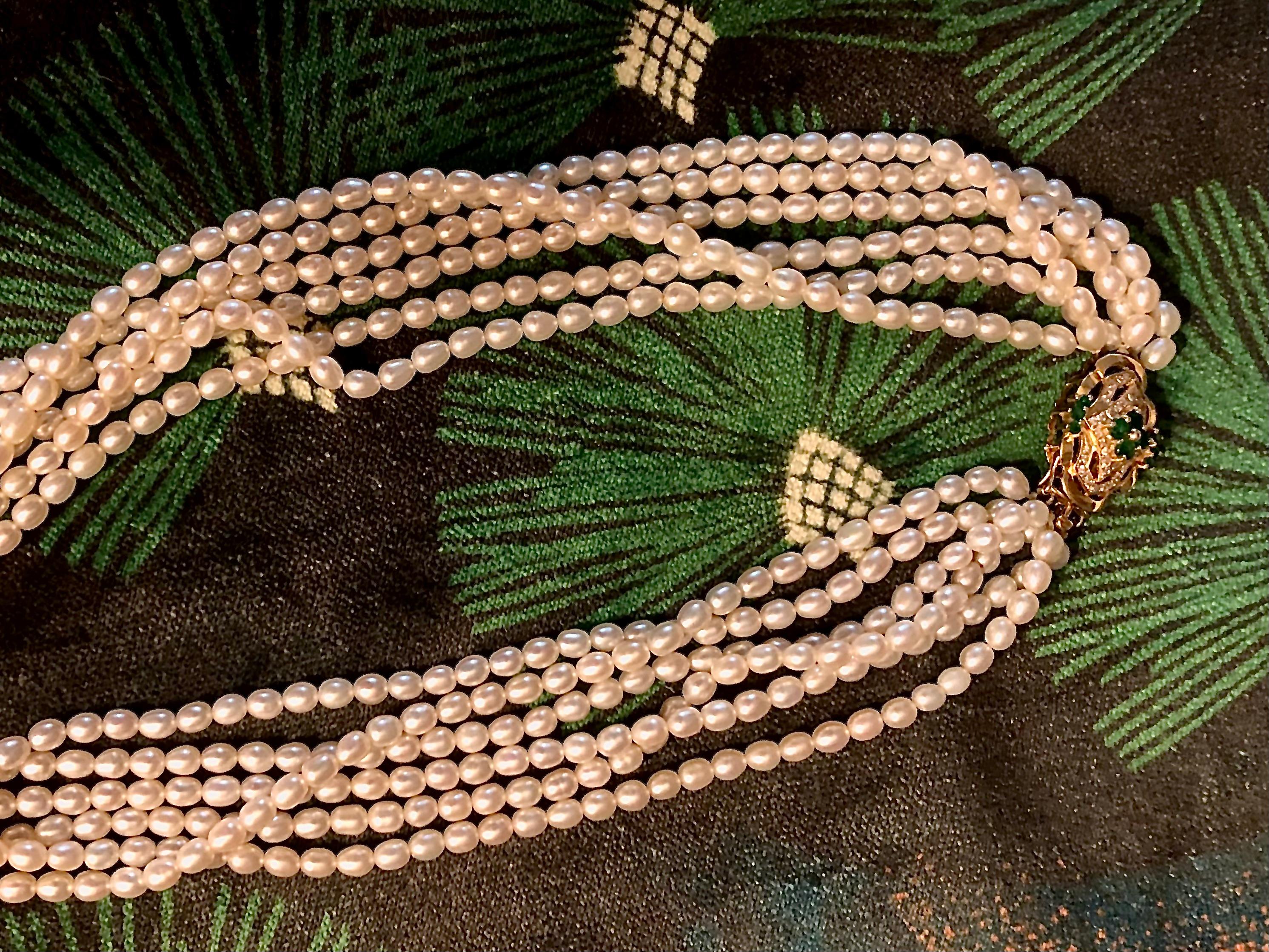 Si tratta di una deliziosa collana a più fili di bellissime perle ovali coltivate d'acqua dolce di colore bianco crema.

La chiusura è in oro giallo 14 carati con smeraldi verde brillante e piccoli diamanti scintillanti. La chiusura sembra fare