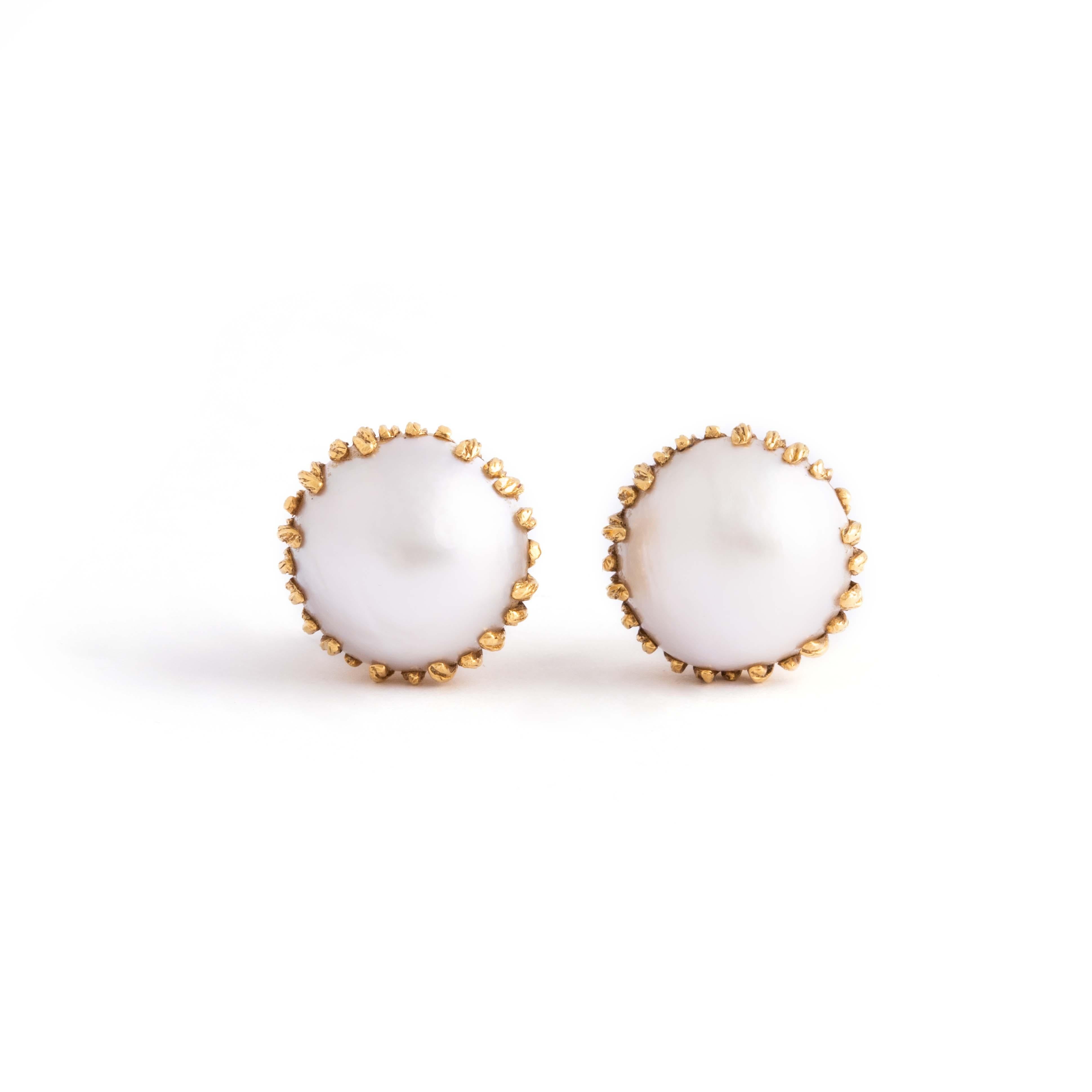 Pair of 18K yellow gold earrings holding respectively a half cultured pearl.
Diameter: 1.80 centimeters. 
Gross weight: 16.19 grams.