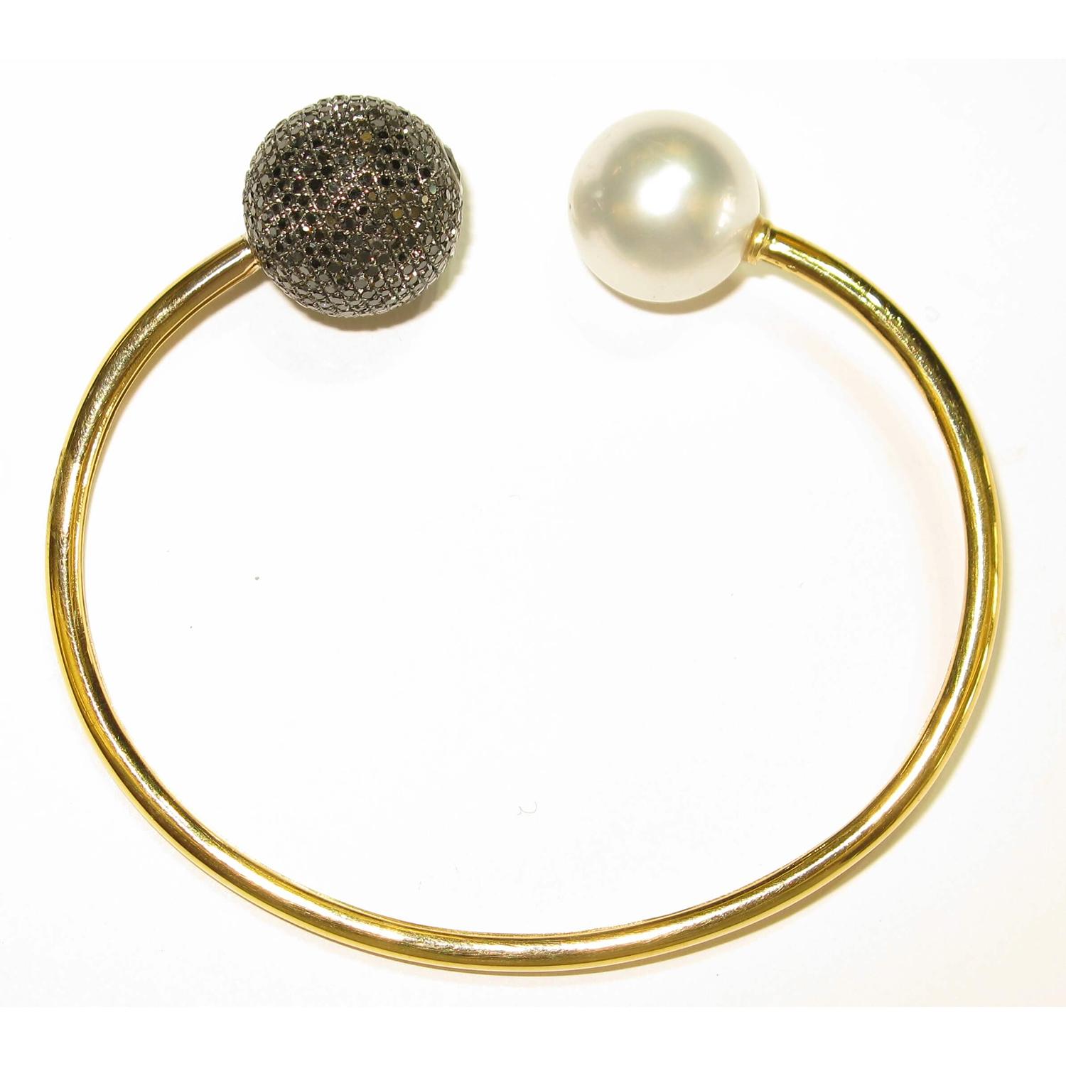 This stunning 18K Gold Pearl & Black Diamond Ball Temper Bangle sits perfectly on most of the wrist sizes. It can worn easily by twisting a little. Match them perfectly with Ball/Tribal earrings by Artisans for any occasion.