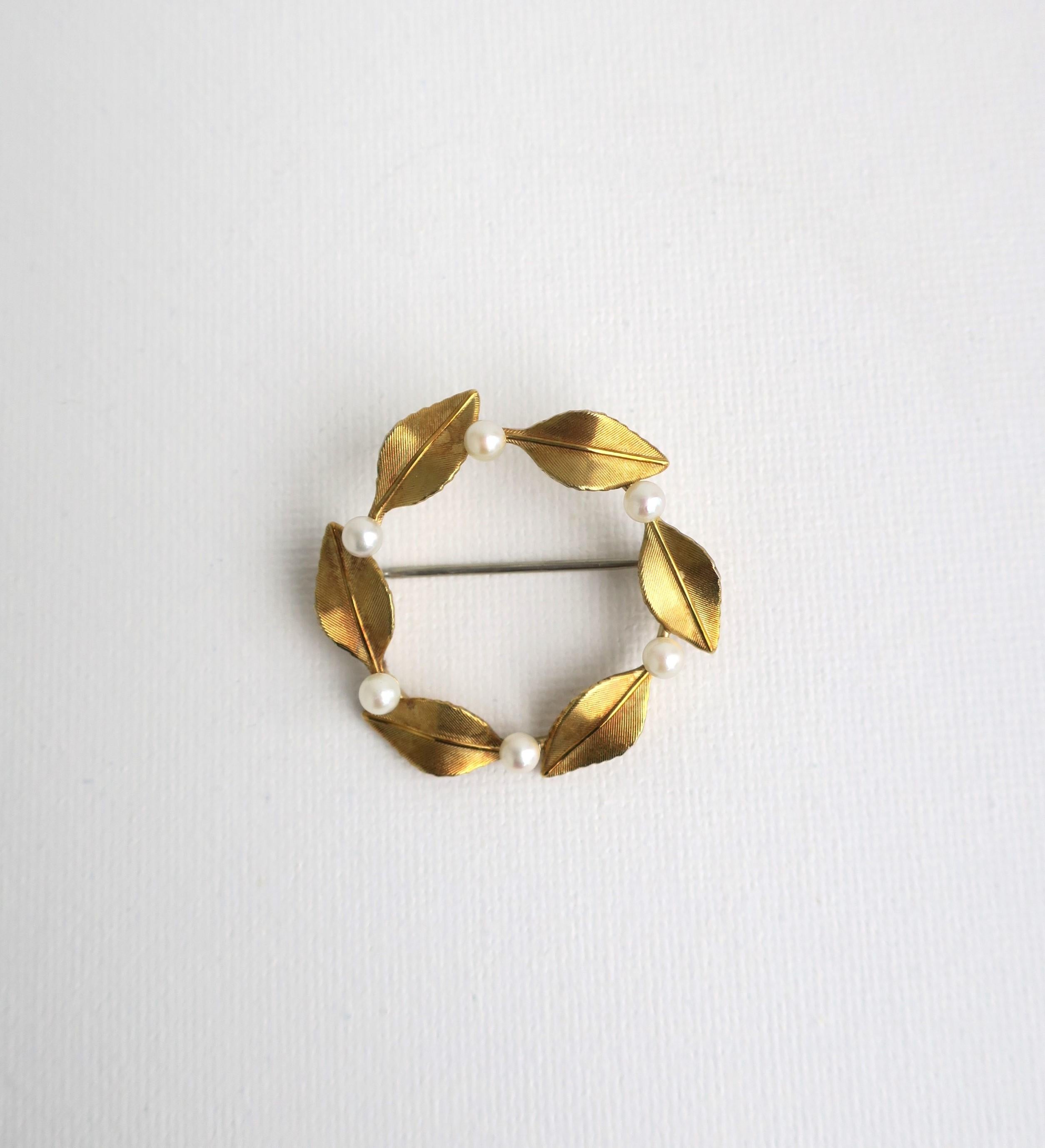 A beautiful, cultured pearl and gold-plated brooch pin with leaf design, circa 1950s, by Krementz, circa mid-20th century, USA. Purchased in New York, New York. Brooch is round with white cultured pearls in-between each leaf. There are six (6)