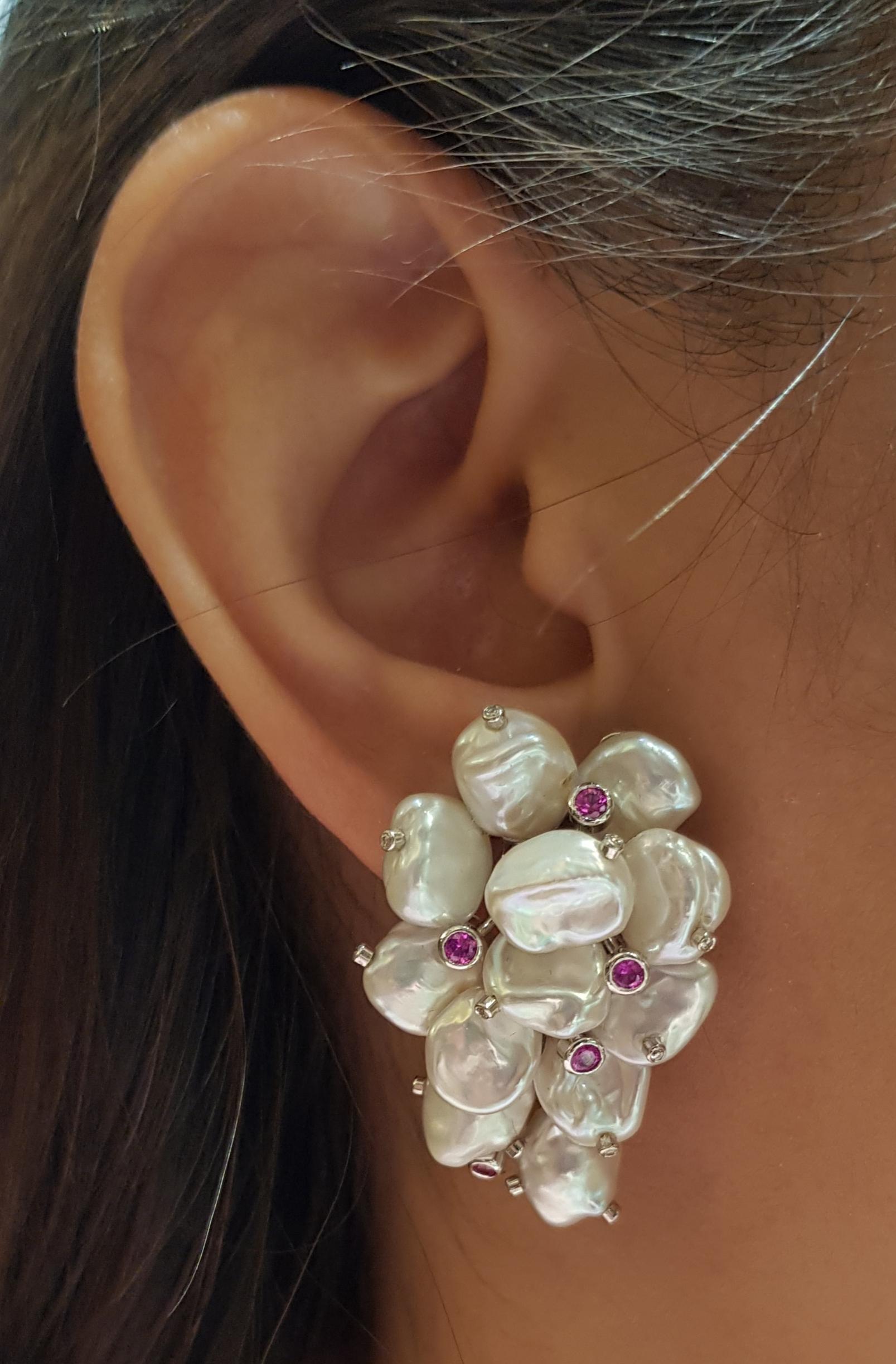 Boucles d'oreilles composées d'une perle, d'un saphir rose de 0,45 carat et d'un diamant de 0,16 carat sertis dans une monture en or blanc 18 carats

Largeur :  2.3 cm 
Longueur :  3.8 cm
Poids total : 24,54 grammes

