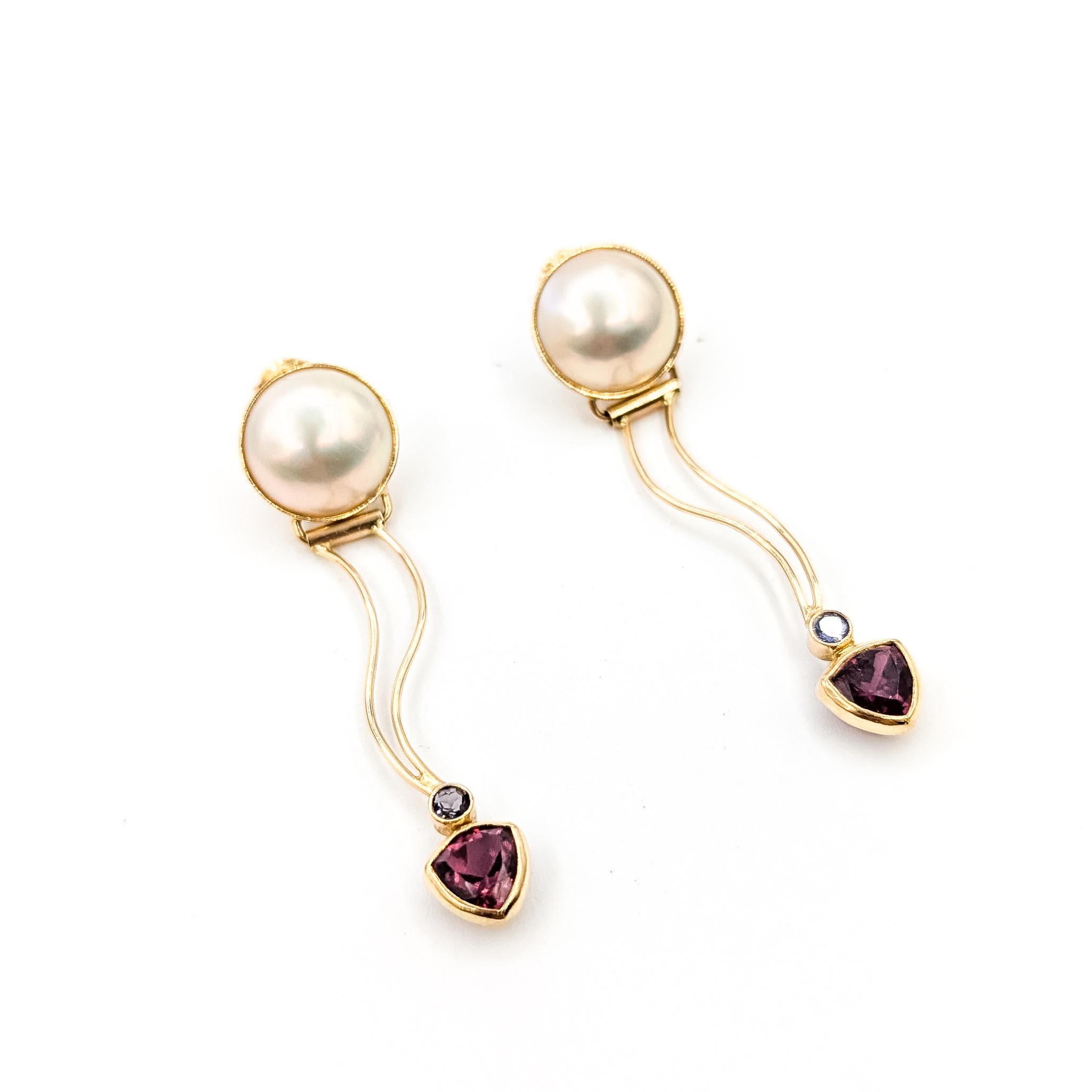 Pendientes de perla, granate frambuesa y tanzanita en oro amarillo de 14k

Estos pendientes estilo gota presentan luminosas perlas blancas de 12,5 mm engastadas en oro amarillo de 14 quilates, combinadas con fluidas líneas de oro que conducen a