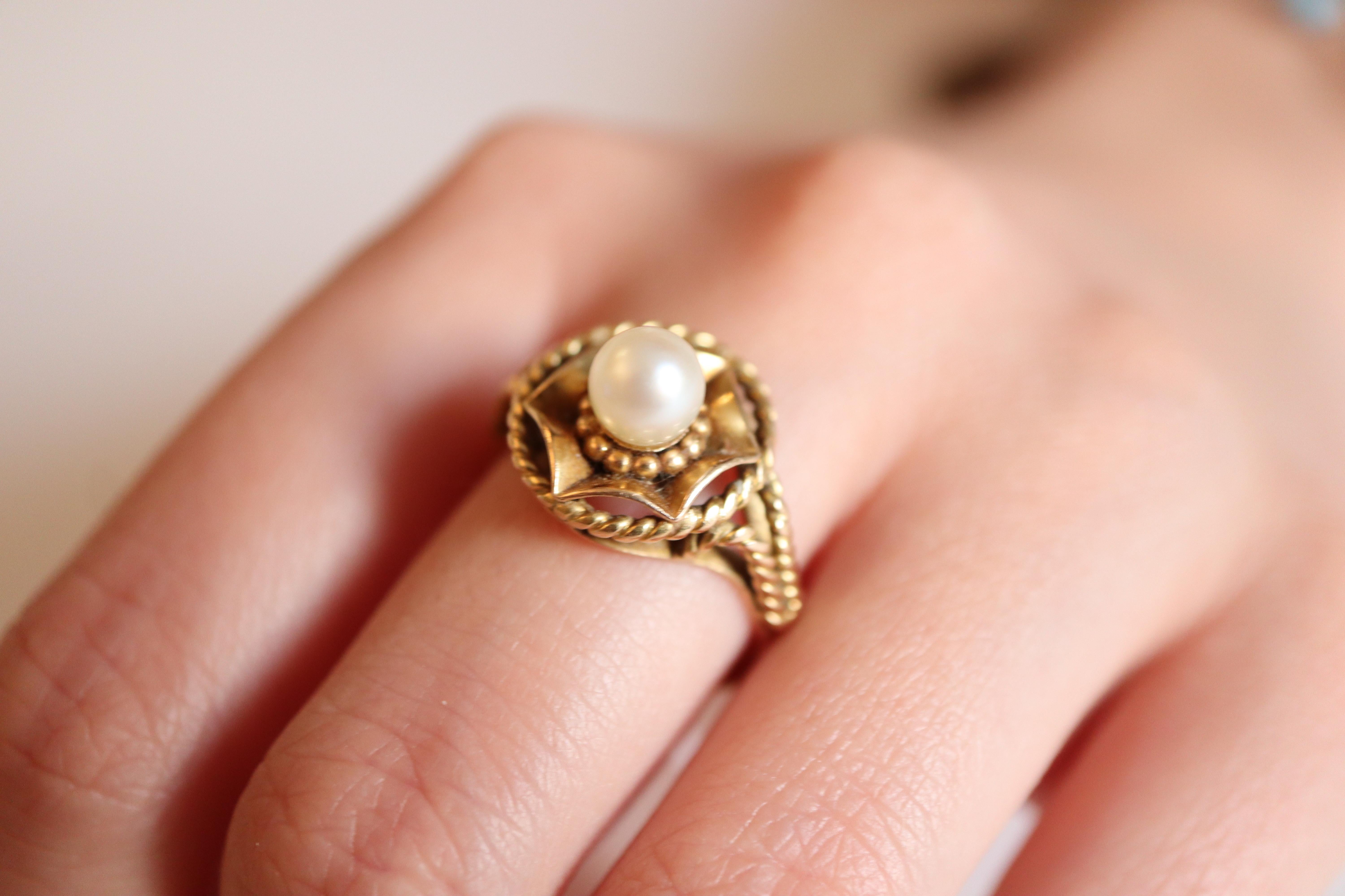 Vintage 18 kt yellow gold ring and a pearl circa 1960
A cultured pearl diameter 5 mm in the center of a basket. 
Twist work on the basket and top of the ring. 
Very good general condition for this vintage jewel.
Eagle's head hallmark 18 carats
