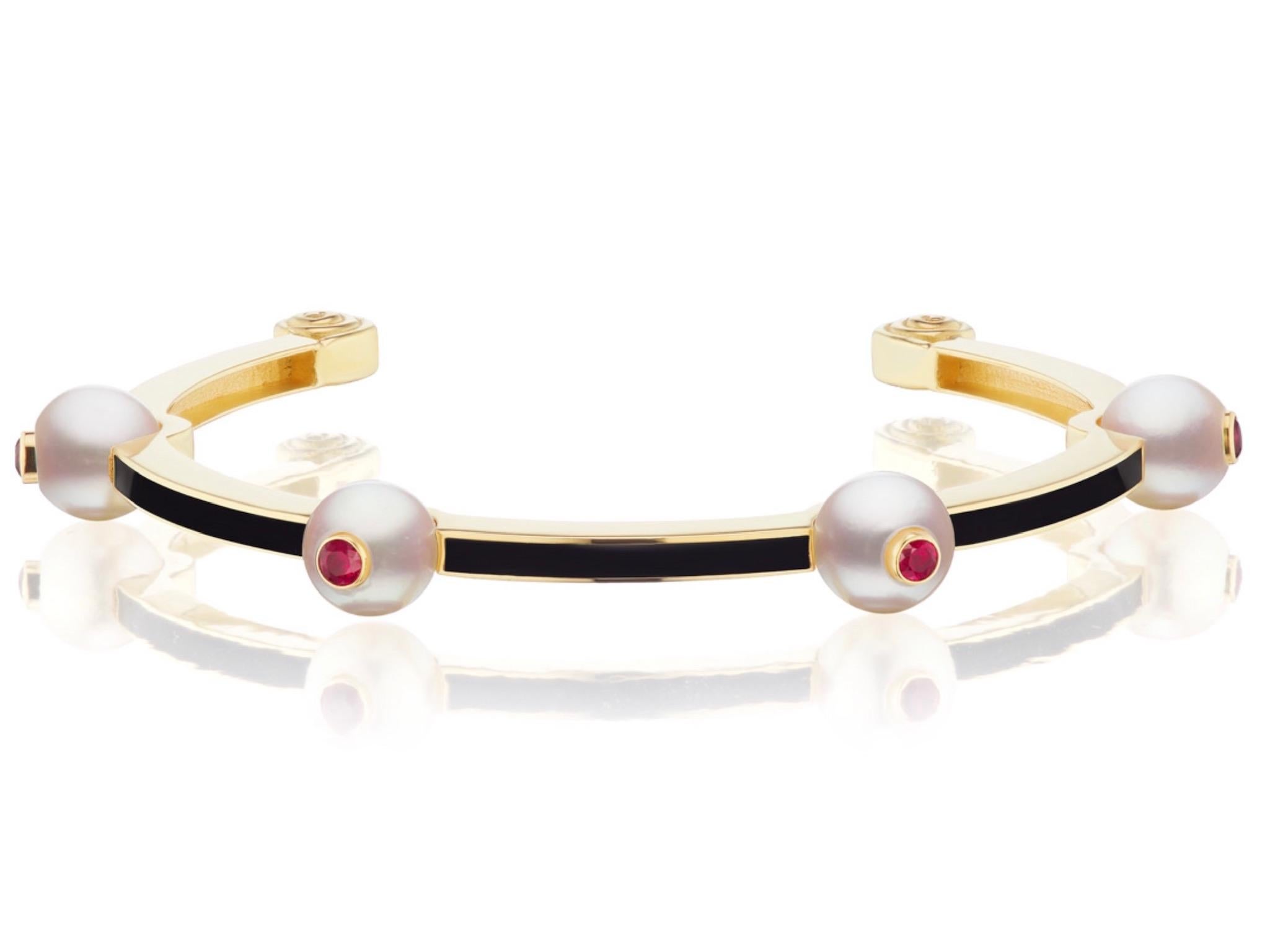 This new bracelet design by Andrew Glassford features 8.5mm Cultured Japanese Akoya Pearls spaced evenly between channels of black enamel. Atop each Pearl is a faceted Ruby to complete this stunning bangle. The rubies total .15 carats in total. This