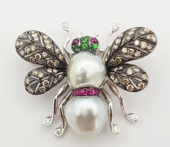 Broche en or blanc 18 carats sertie de perles, de rubis, de diamants bruns et de rubis cabochon