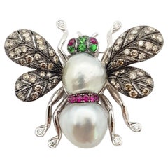 Broche en or blanc 18 carats sertie de perles, de rubis, de diamants bruns et de rubis cabochon