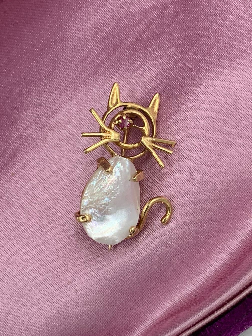 An adorable Cat or Kitten Retro Mid-Century Modern Brooch Pin with a Pearl body and Ruby eye in 10 Karat Gold.  The cat has great Mid-Century Modernist style and design!  The adorable cat has a wonderful open work face and whiskers.  The eye is a