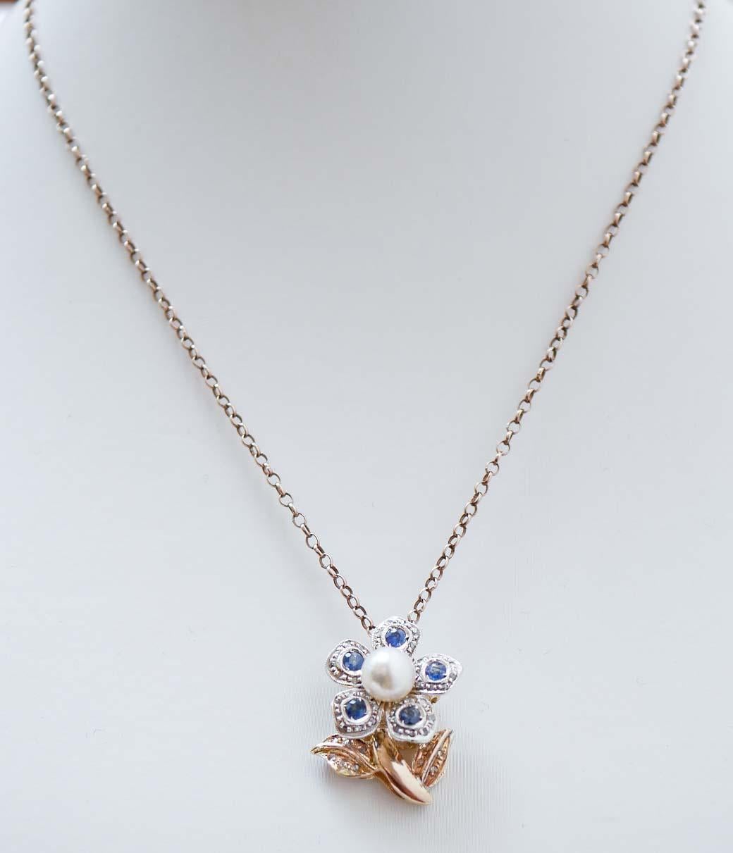Incredibile ciondolo a forma di fiore in oro rosa 14 kt e struttura in argento con perla centrale e foglie tempestate di zaffiri e diamanti. In basso, foglie tempestate di diamanti.
Il ciondolo viene fornito con una catena di gomma con chiusura in