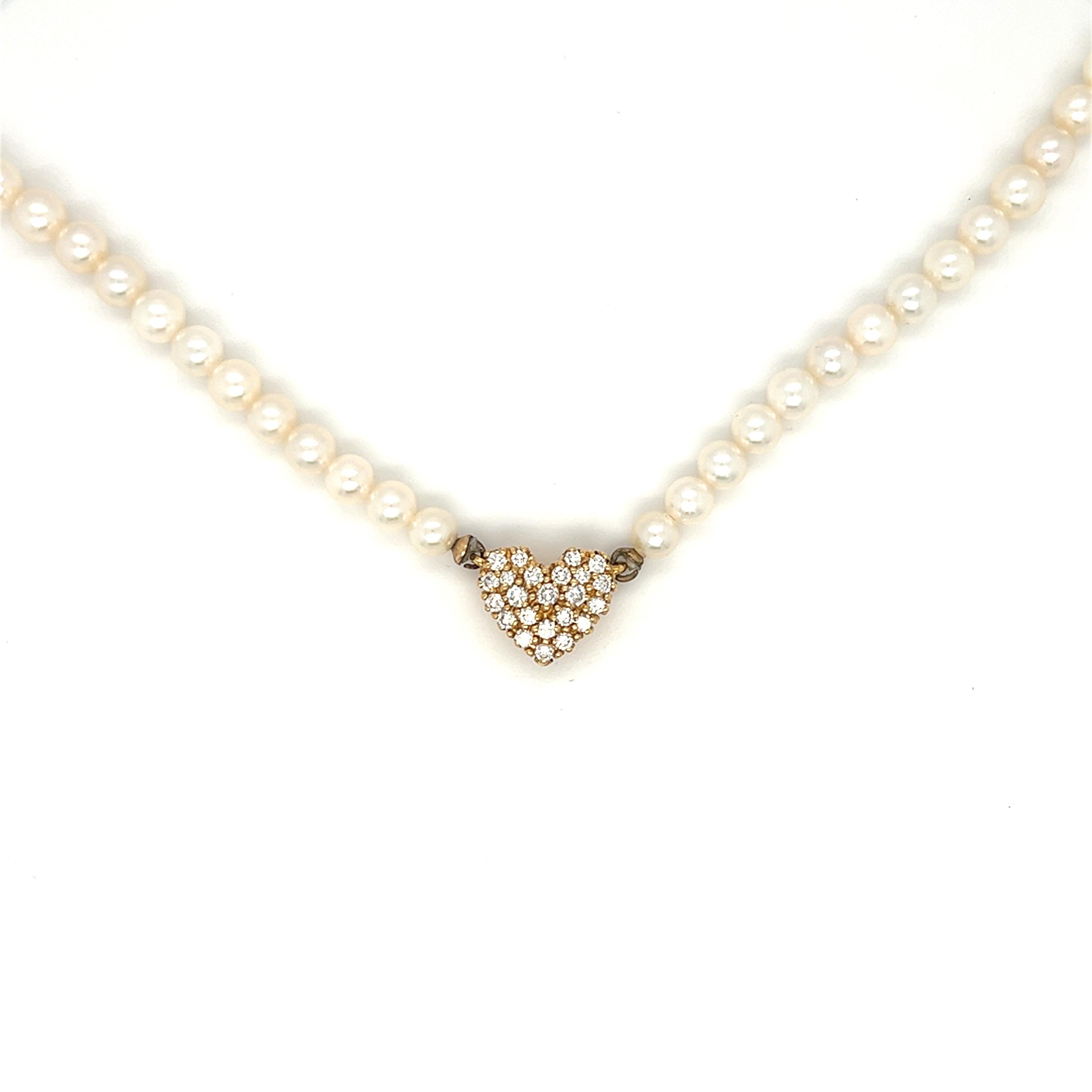 A very pretty cluster diamond heart charm pendant affixed to a luscious strand of cultured pearls. The heart carries total weight of 1.00 carat round brilliant diamond with G-H color and VS2 clarity. The heart charm is stamped 18KP. The necklace
