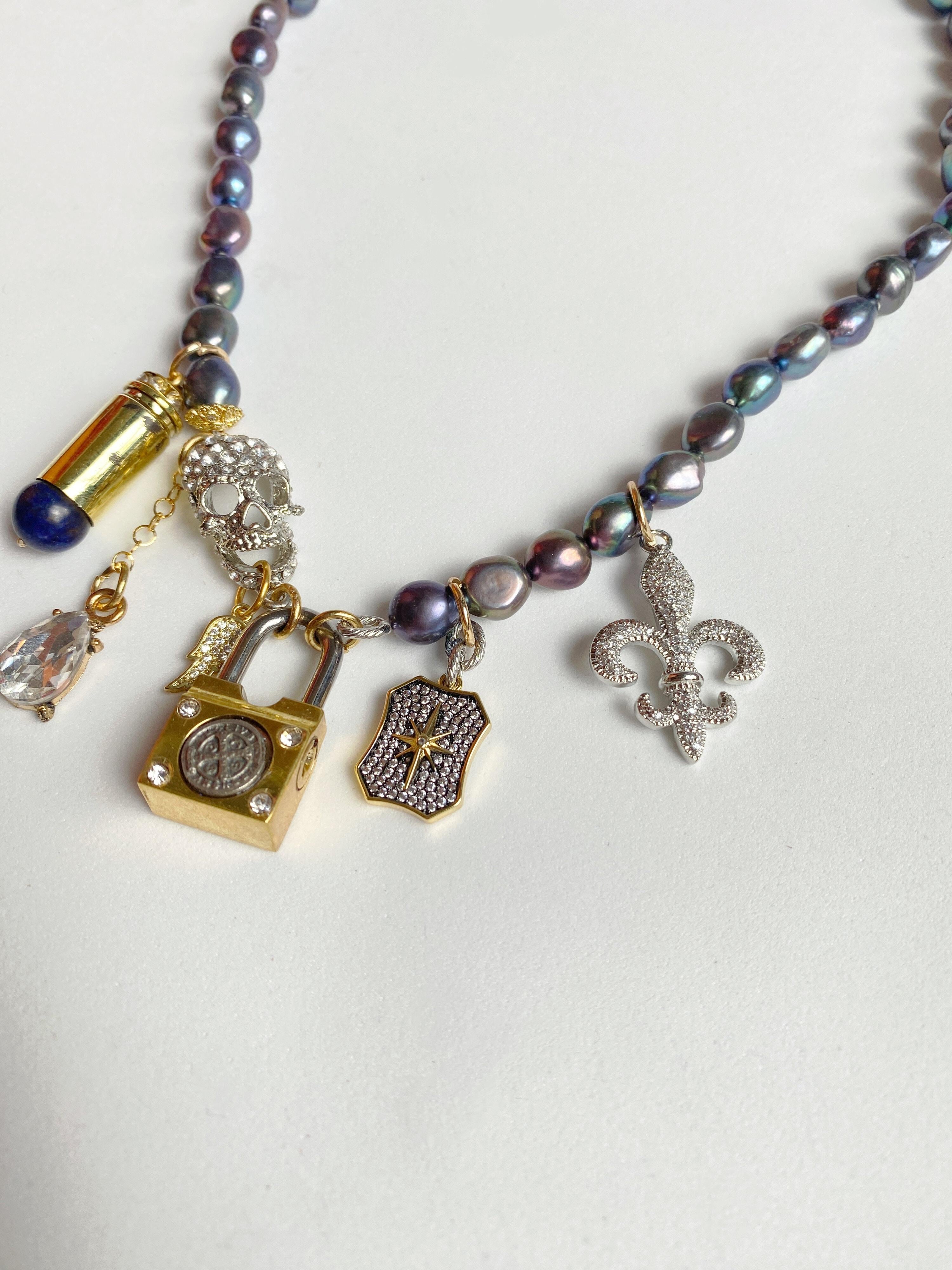 These pearl and lock necklaces are all custom made, making each one completely unique. You can customize from white to black pearl, each gold filled lock is engraved with the owners initials, and set with your choice of charms depending on your