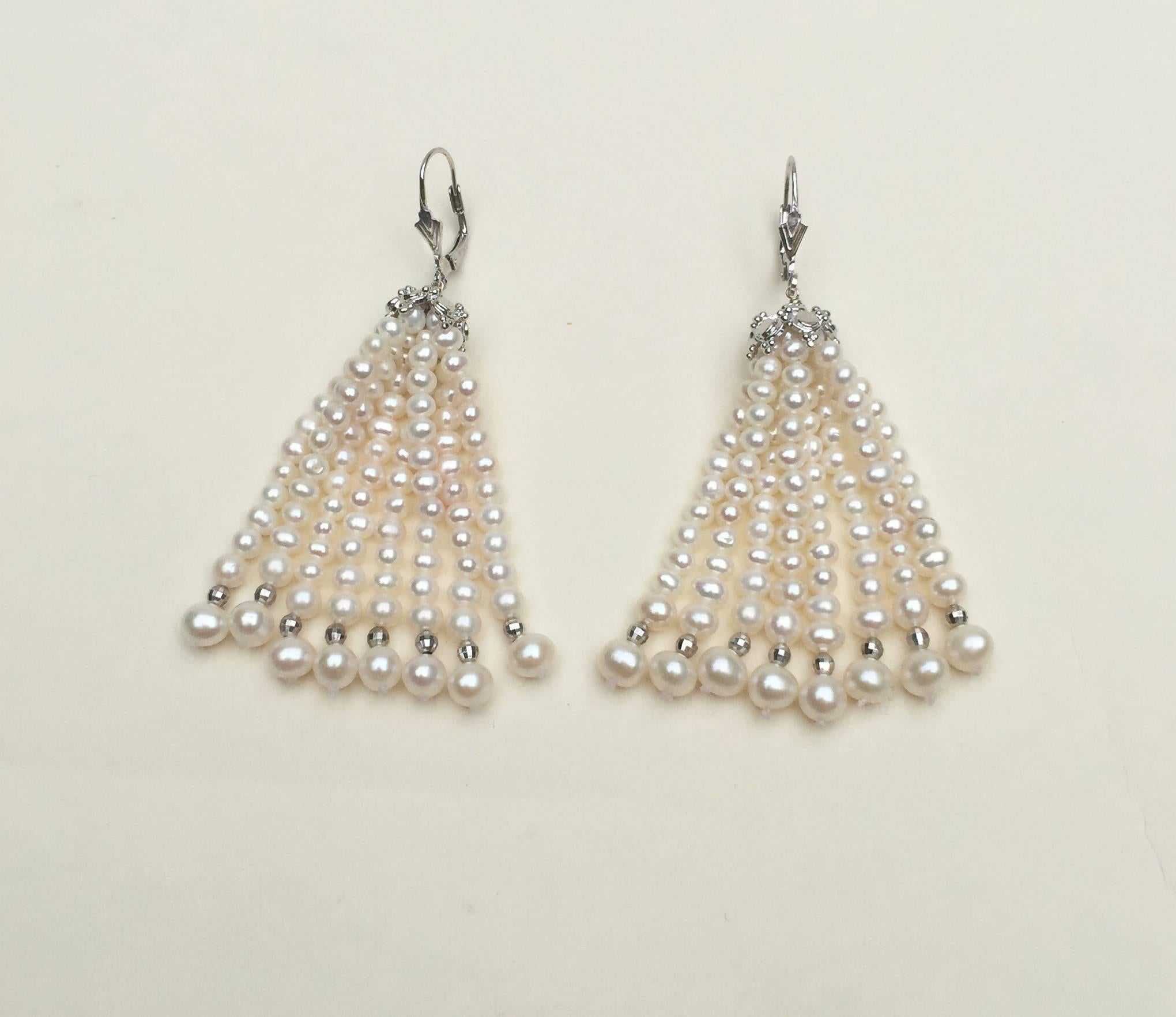 These pearl tassel earring are graduated pearls ranging from 3 mm - 5 mm, highlighted by 14 k white gold beads and a white gold plated silver cup. The cup is designed with a graduated design to mirror the graduated tassel. The lever back is 14 k