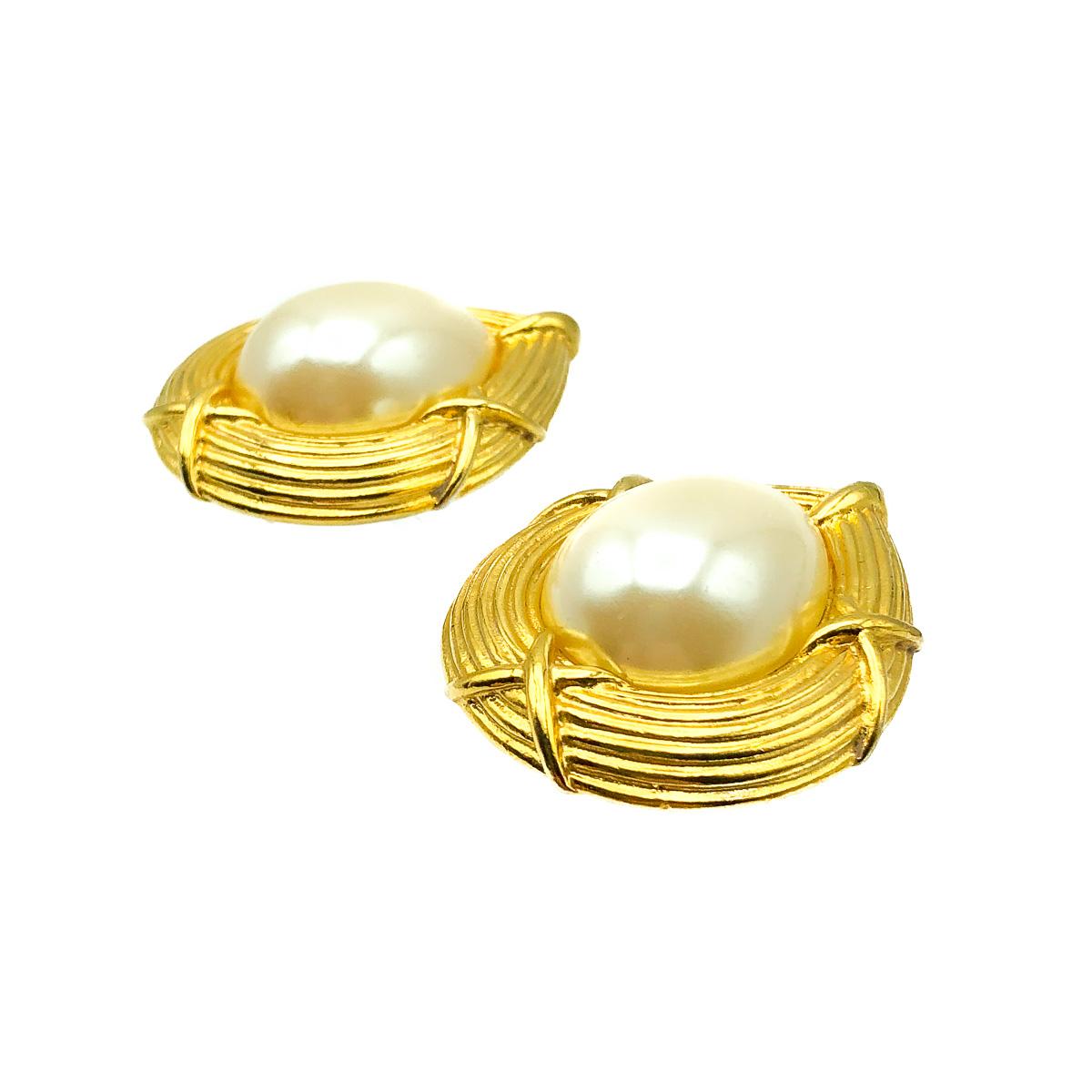 A Pearl Teardrop Kiss Earring. A striking gallery, ribbed and with criss-crossing, reminds us of kisses! Crafted in gold plated metal with a central large glass faux pearl. Wonderful quality. Very good vintage condition, 4cms. A stunning pair of