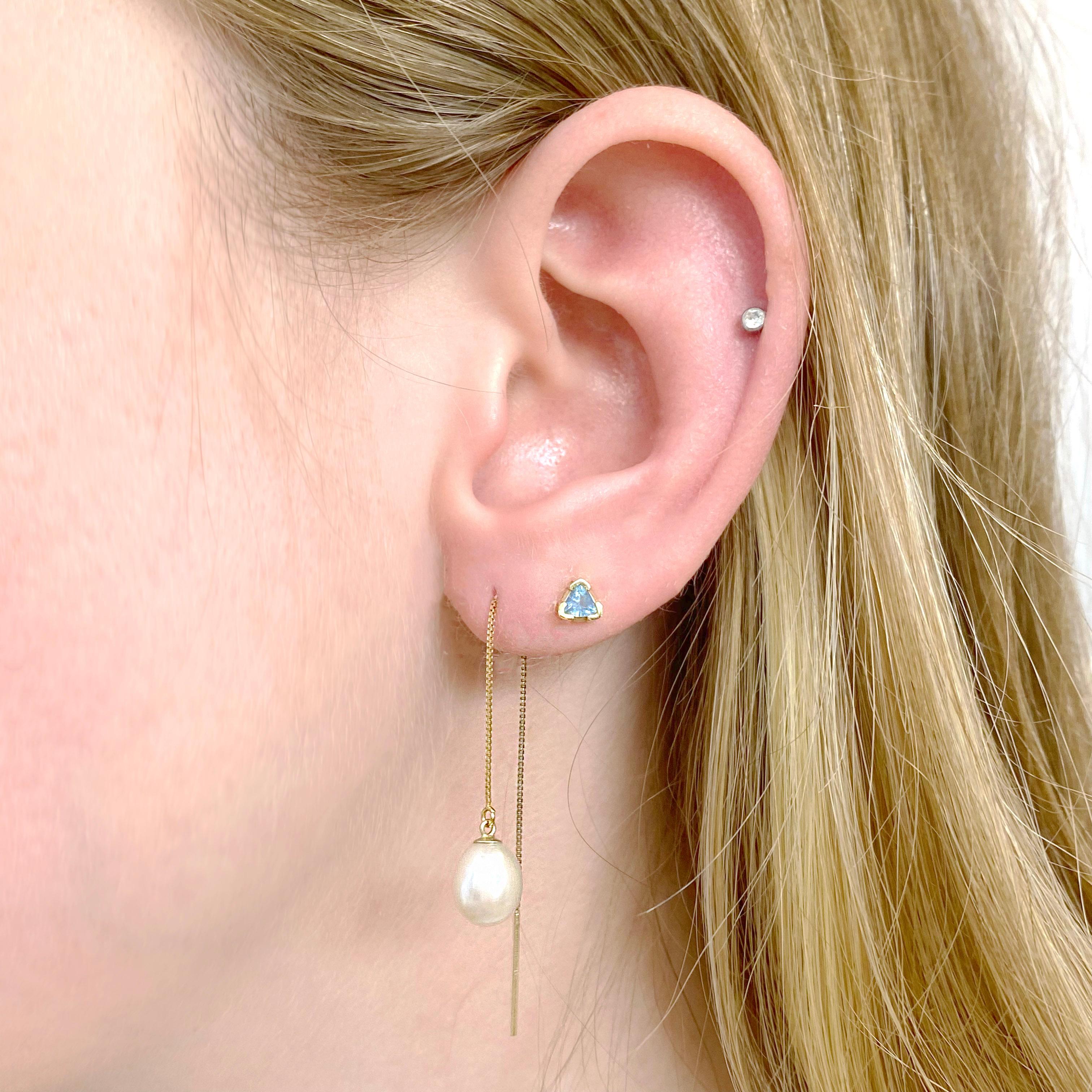Threaders are the perfect look for 2022! These earring threaders are constructed out of 14 karat yellow gold chain that has a gold par on the end to make it easy to put on. The pearls on the front have a slight teardrop shape and are an ideal match.