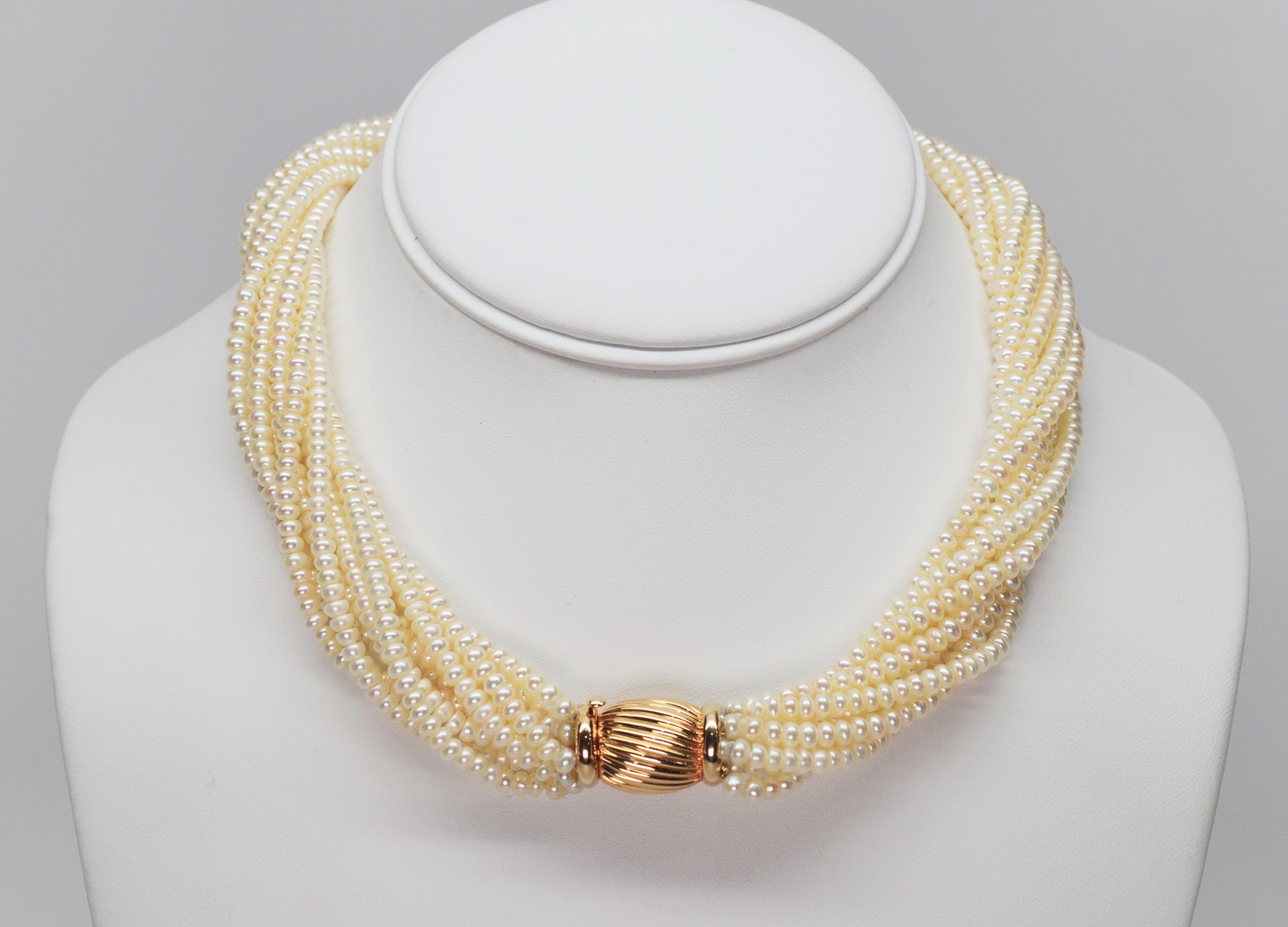 This elegant two piece necklace and bracelet set is abundantly strung with ten strands of 3.75 freshwater button pearls. The necklace, in a sixteen inch length, features a substantial fourteen carat yellow gold decorative bow tie clasp that can be
