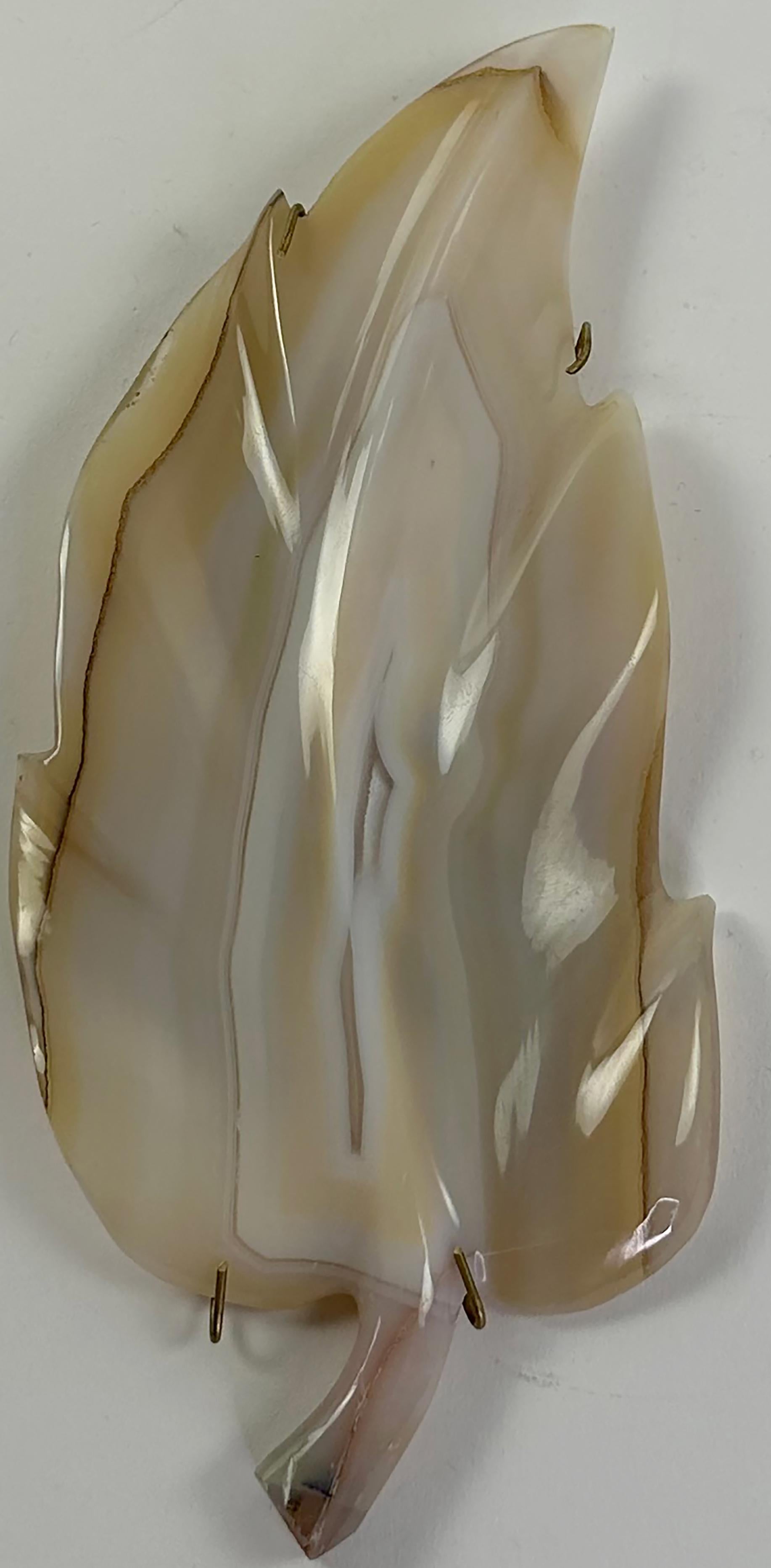 An intriguing custom carved and polished sculptural leaf. Made from agate in a pearl white color with a few light gray and brown highlights. Thin brown lines are set on both sides of the leaf.

In very good condition. Some gentle wear and aging