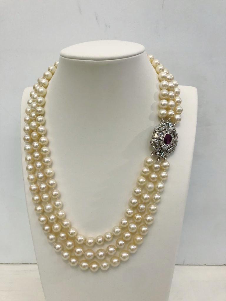 Italienisches Vintage Collier mit drei Strängen aus japanischen 7/7,5 mm Perlen, Verschluss aus 18 Karat Weißgold mit einem zentralen Rubin von 1,5 Karat und Brillanten von insgesamt 2,5 Karat / Made in Italy 1950er Jahre
Länge 45cm
