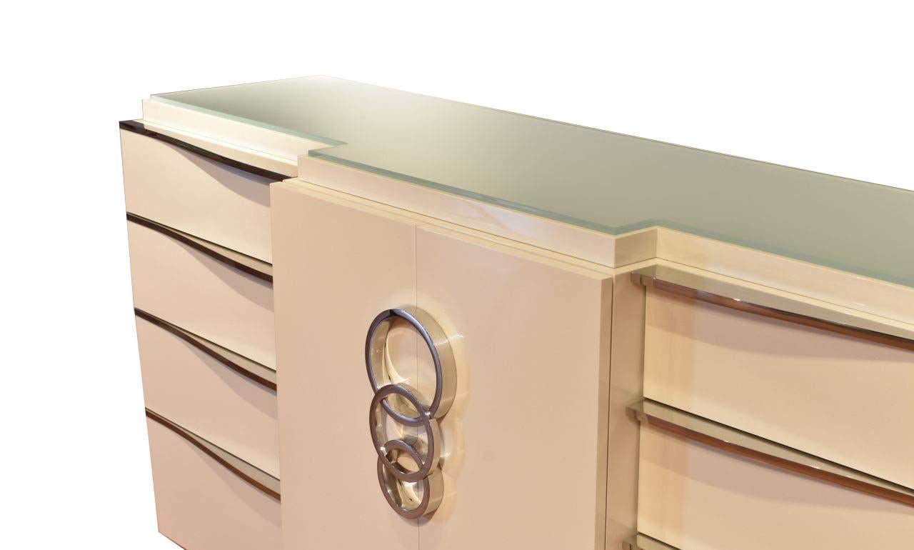 The Rings Buffet is made of a high glass pearlized lacquer and is a great addition to your home. The is a custom made, polished stainless steel handle for the door as well as the drawer pulls. The piece also has a highly detailed etched glass top.