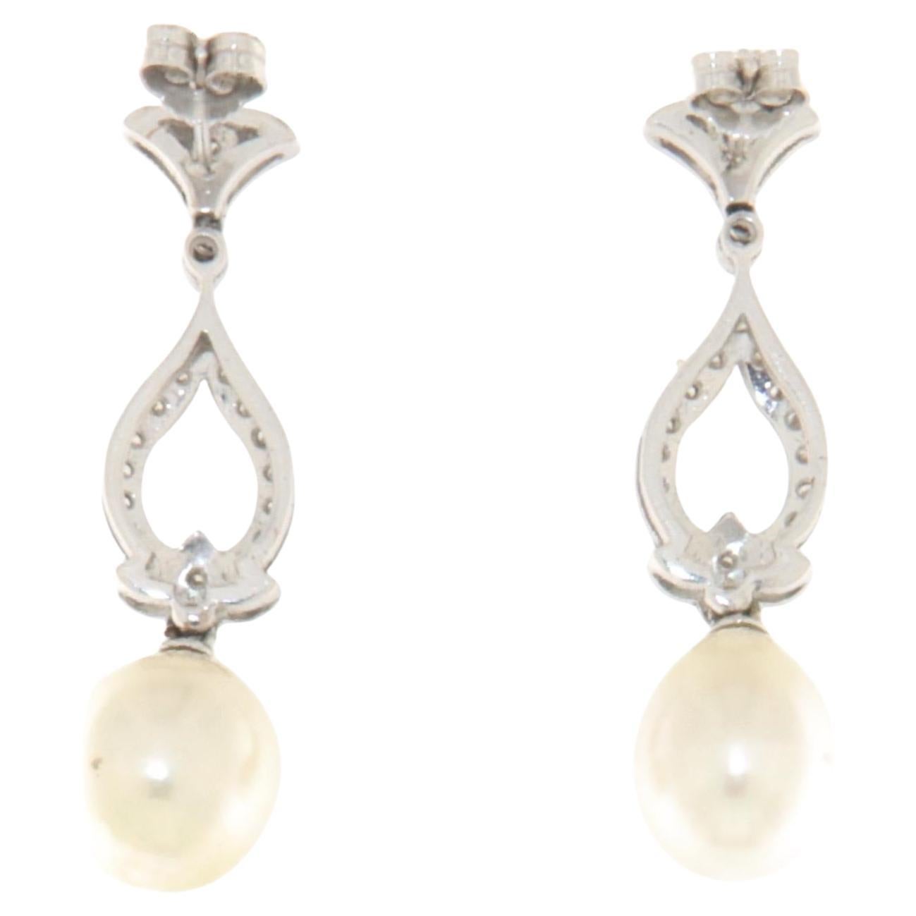 These stunning drop earrings are crafted in 18-carat white gold, combining elegance and refinement in a unique design. The structure of the earrings is adorned with set diamonds, creating a luminous effect that captures light with an intense and