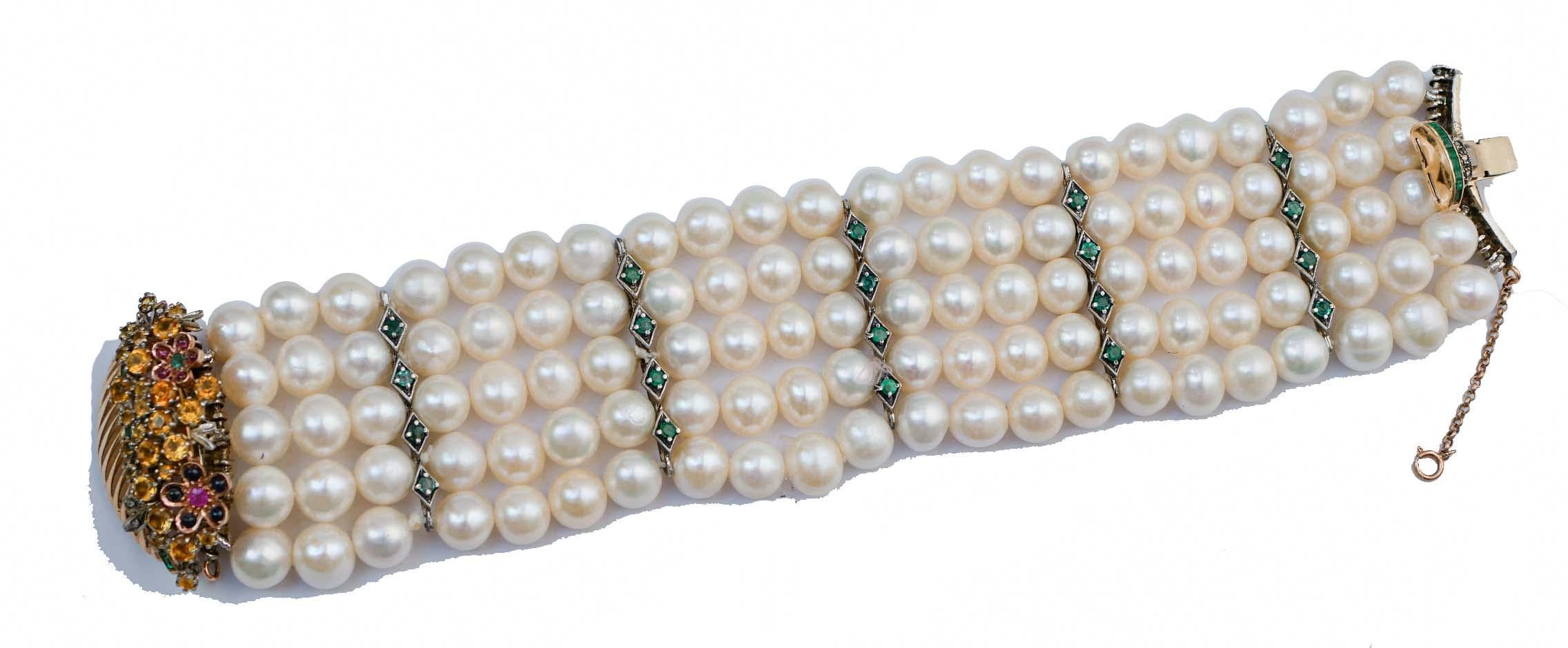 Fantastic bracelet mounted with five strands of pearls alternated with structures in silver mounted with diamonds.  As clasp, a basket in 9 kt rose gold and silver mounted with diamonds, emeralds, rubies and sapphires.
This bracelet was totally