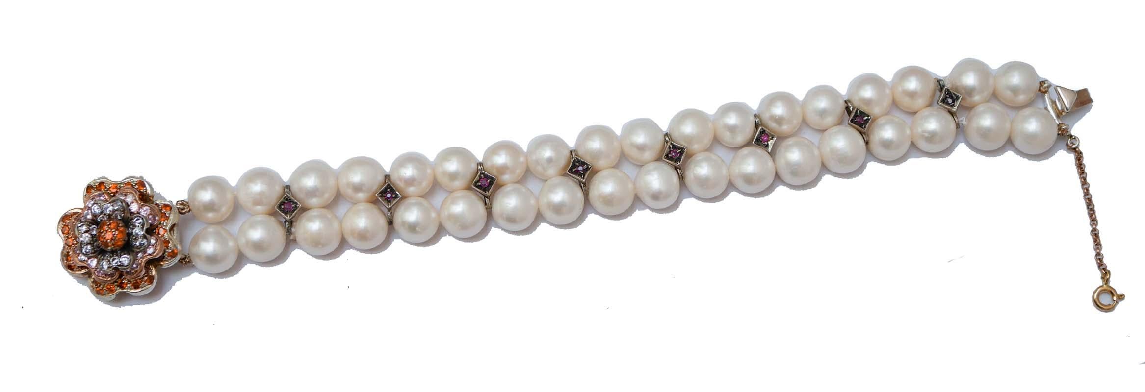 Fantastic retrò bracelet mounted with two strands of pearls with silver structures mounted with a ruby. As clasp, a flower in 9 kt rose gold and silver structure studded with multicolor stones.
This bracelet was totally handmade by Italian master