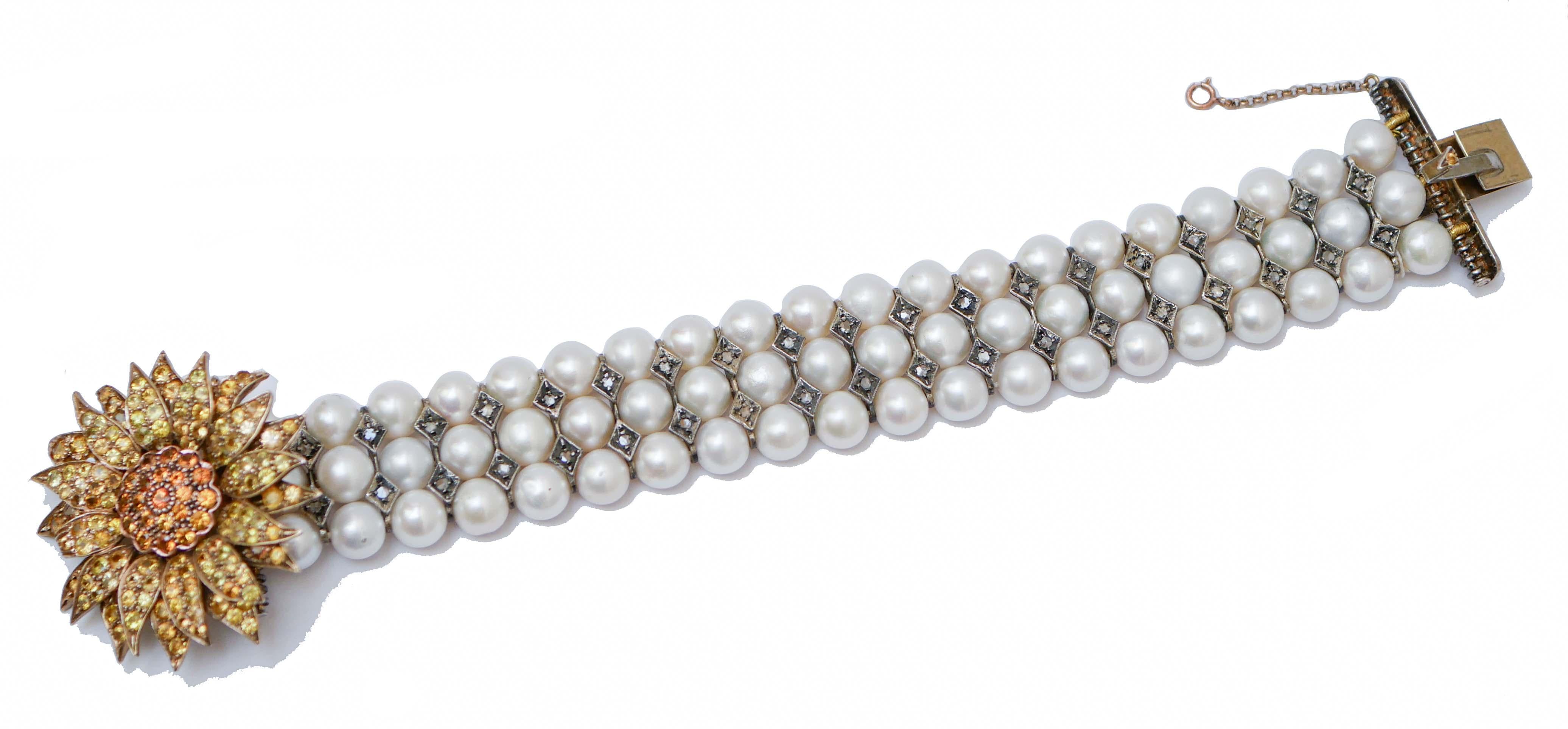 Bracciale fashion retrò montato con perle e, tra di esse, strutture in argento con diamanti.
Come chiusura, un fiore in oro rosa 9 kt e struttura in argento tempestato di zaffiri.
Questo bracciale è stato realizzato totalmente a mano da maestri