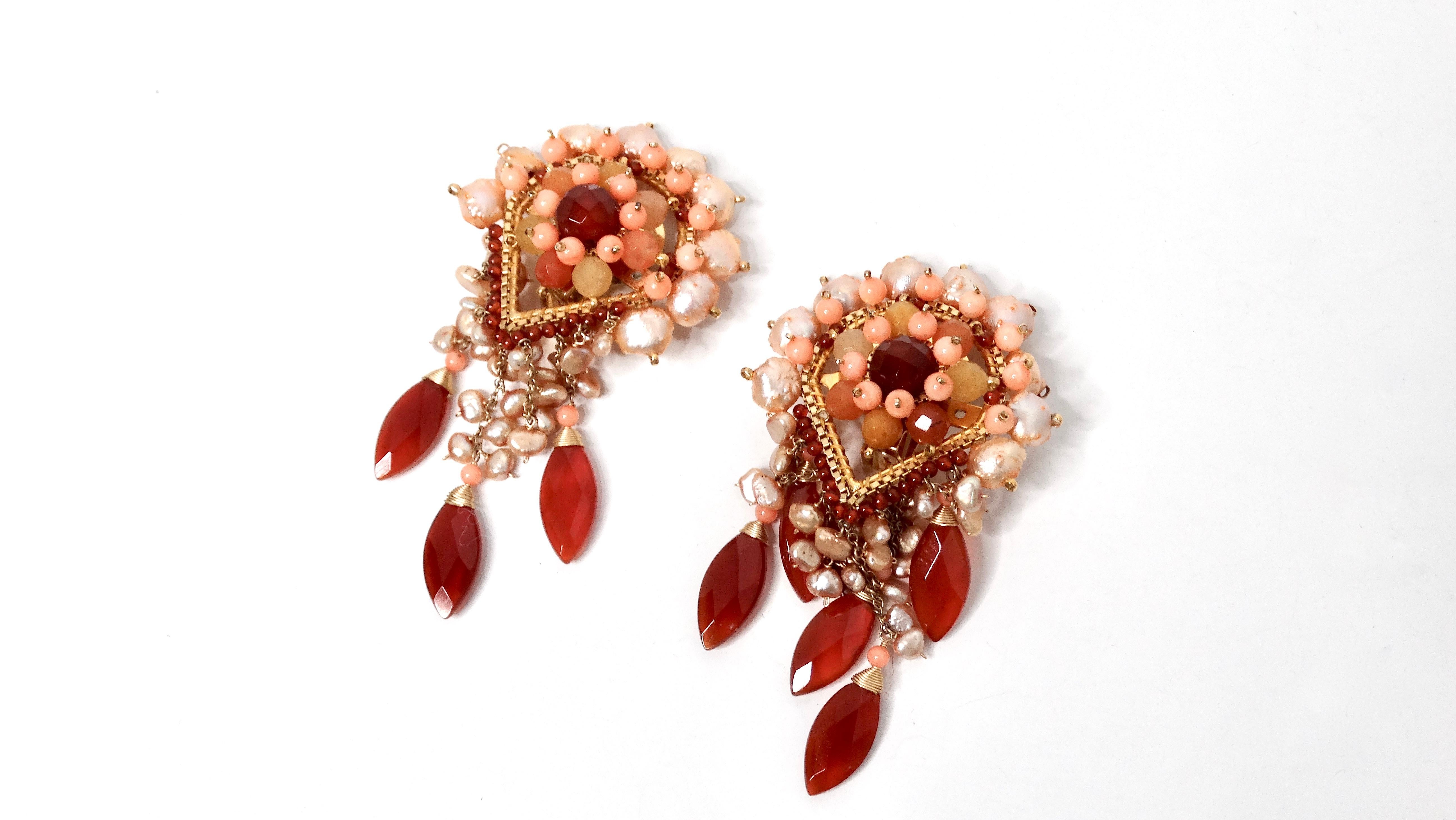 Transformez votre collection d'accessoires avec les boucles d'oreilles clipsées en perles nacrées roses et orange, un hommage stupéfiant à la beauté des capteurs de rêves. Ces boucles d'oreilles accrocheuses présentent un ensemble de perles