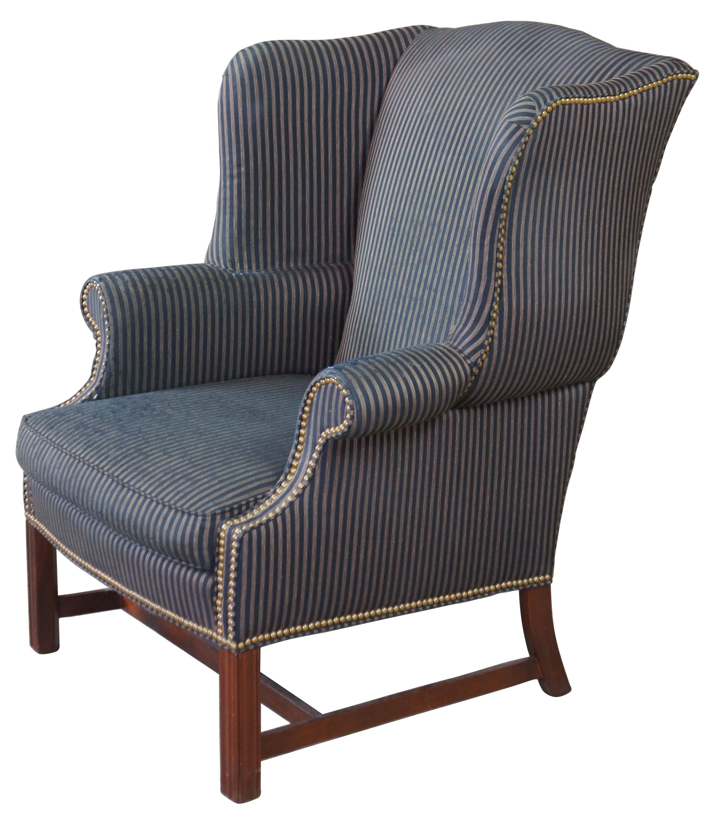 Vintage Pearson Furniture George III or Chippendale wingback chair. Made from mahogany, featuring a rolled arm with high flared wingback covered in a distressed blue pinstripe fabric accented with nailhead trim.
 
