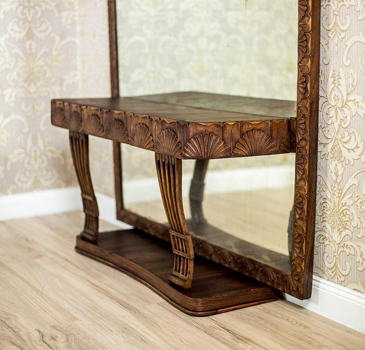 We present you this vanity table composed of a console that adheres to the wall, and a mirror reaching the ground.
The console is supported on legs, which are placed on a pedestal.
Under the top, there are three small drawers hidden in the